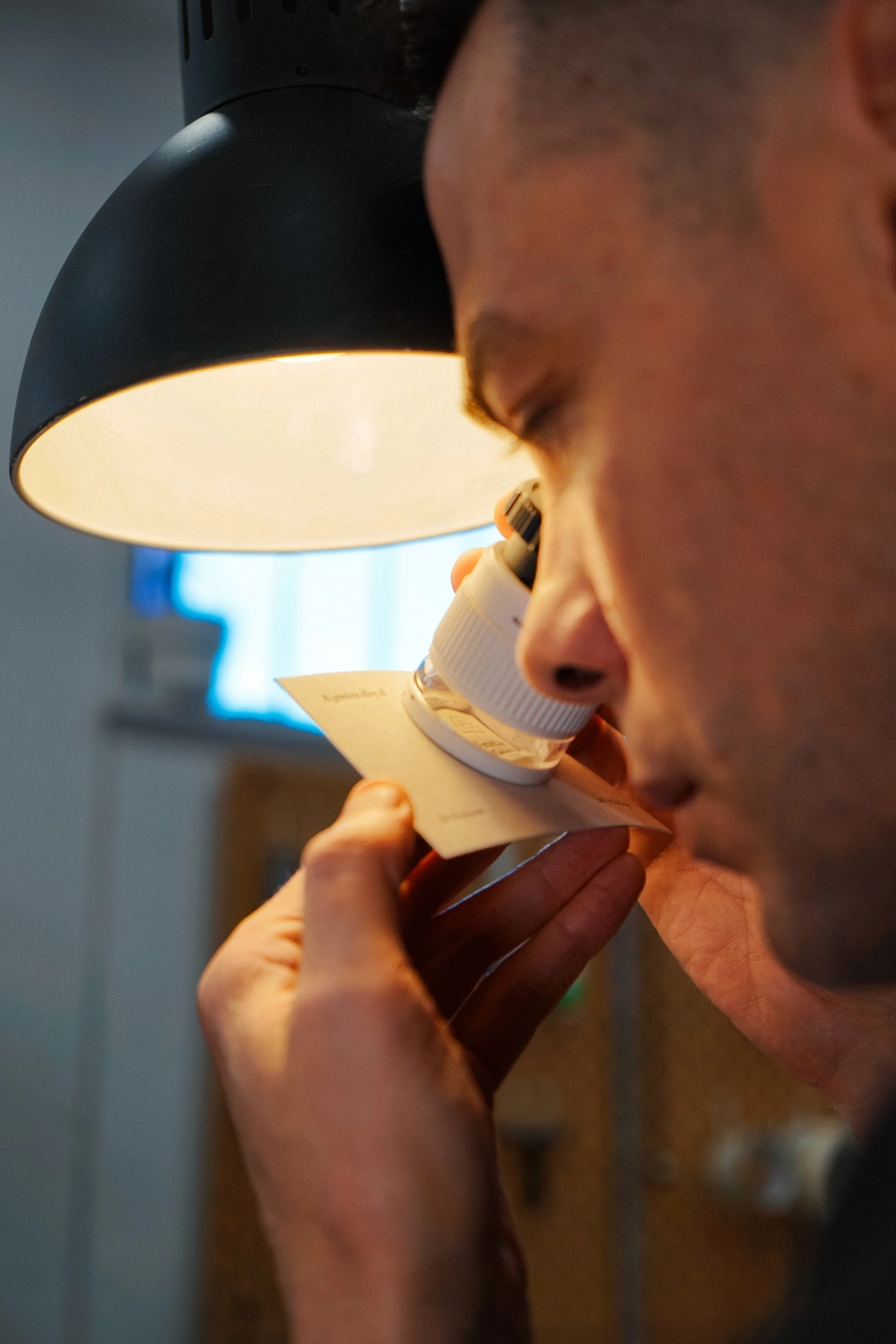 A person looking through a microscope in a laboratory setting.