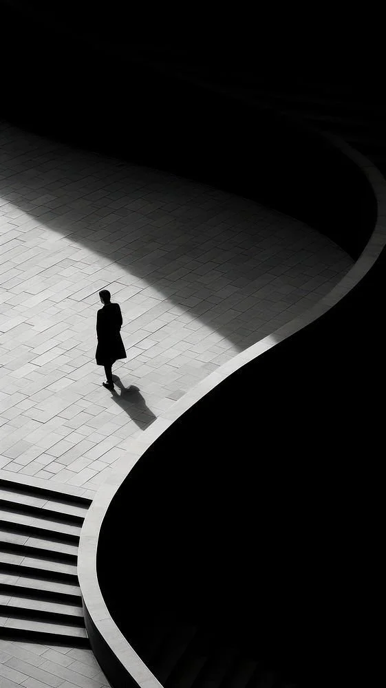 Lone figure crossing a curving sunlit plaza — each client engaged on their own brief, risk profile and definition of success.