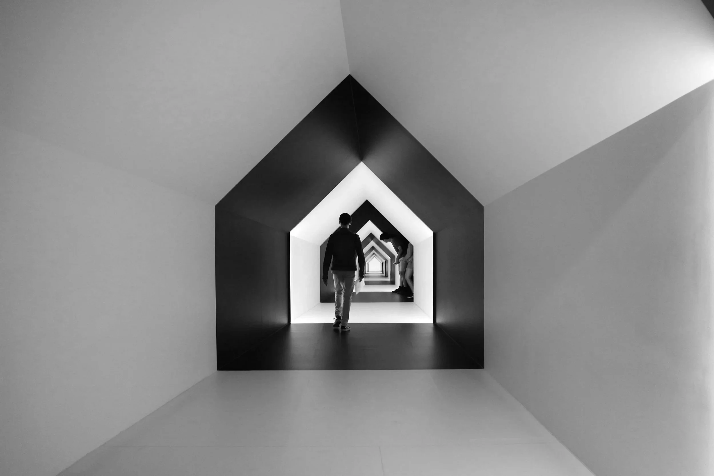 Figure standing in an architectural corridor — Operational Integration across hospitality project design phases.