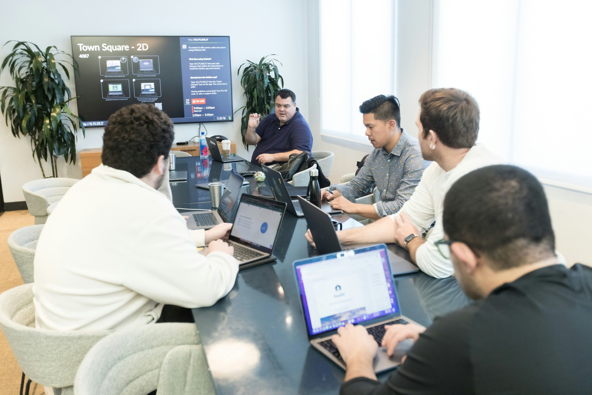 Startup team collaborating in a modern office while scaling their business with structured IT support, employee onboarding, and Google Workspace management.