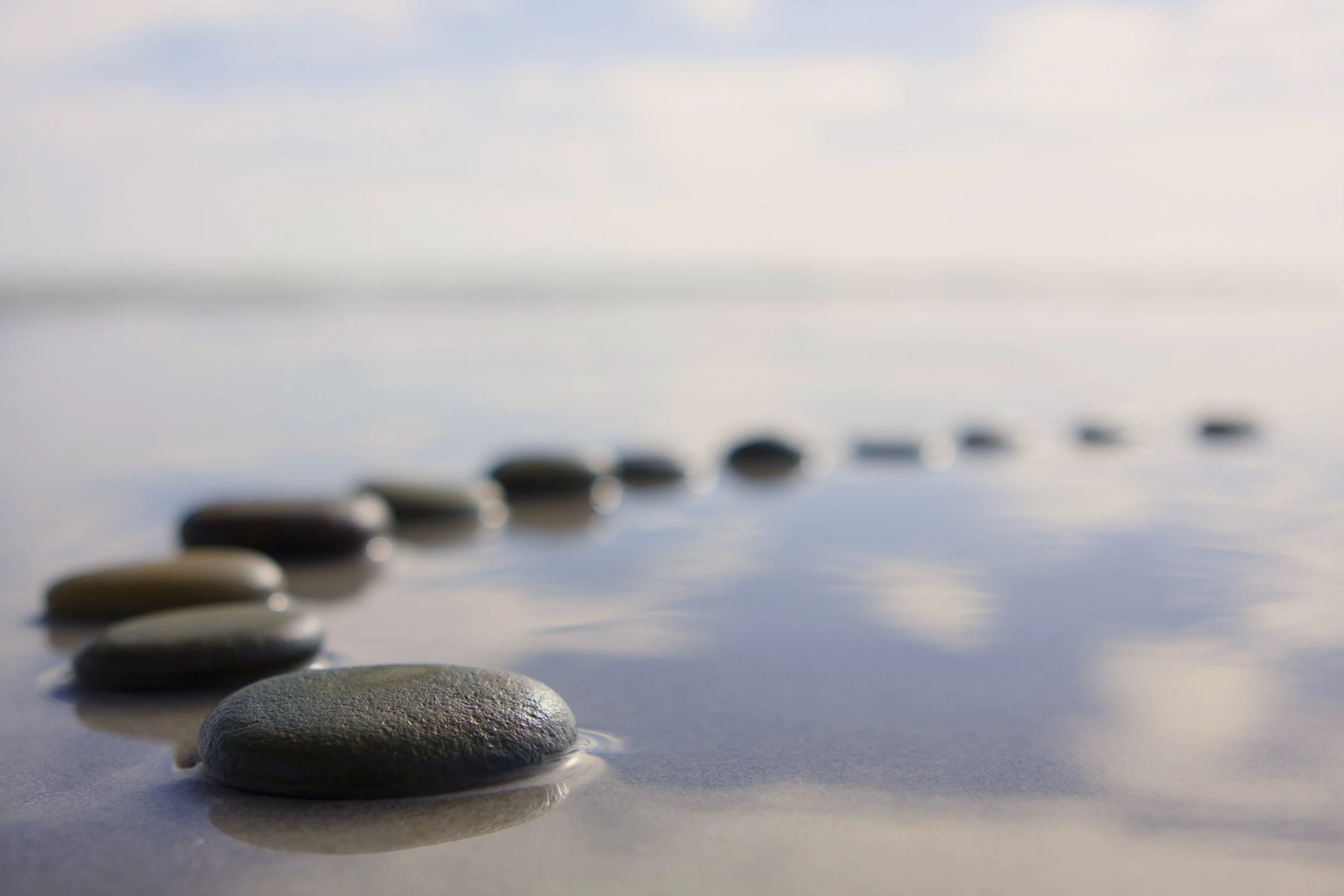 Smooth stacked stones balanced over still water