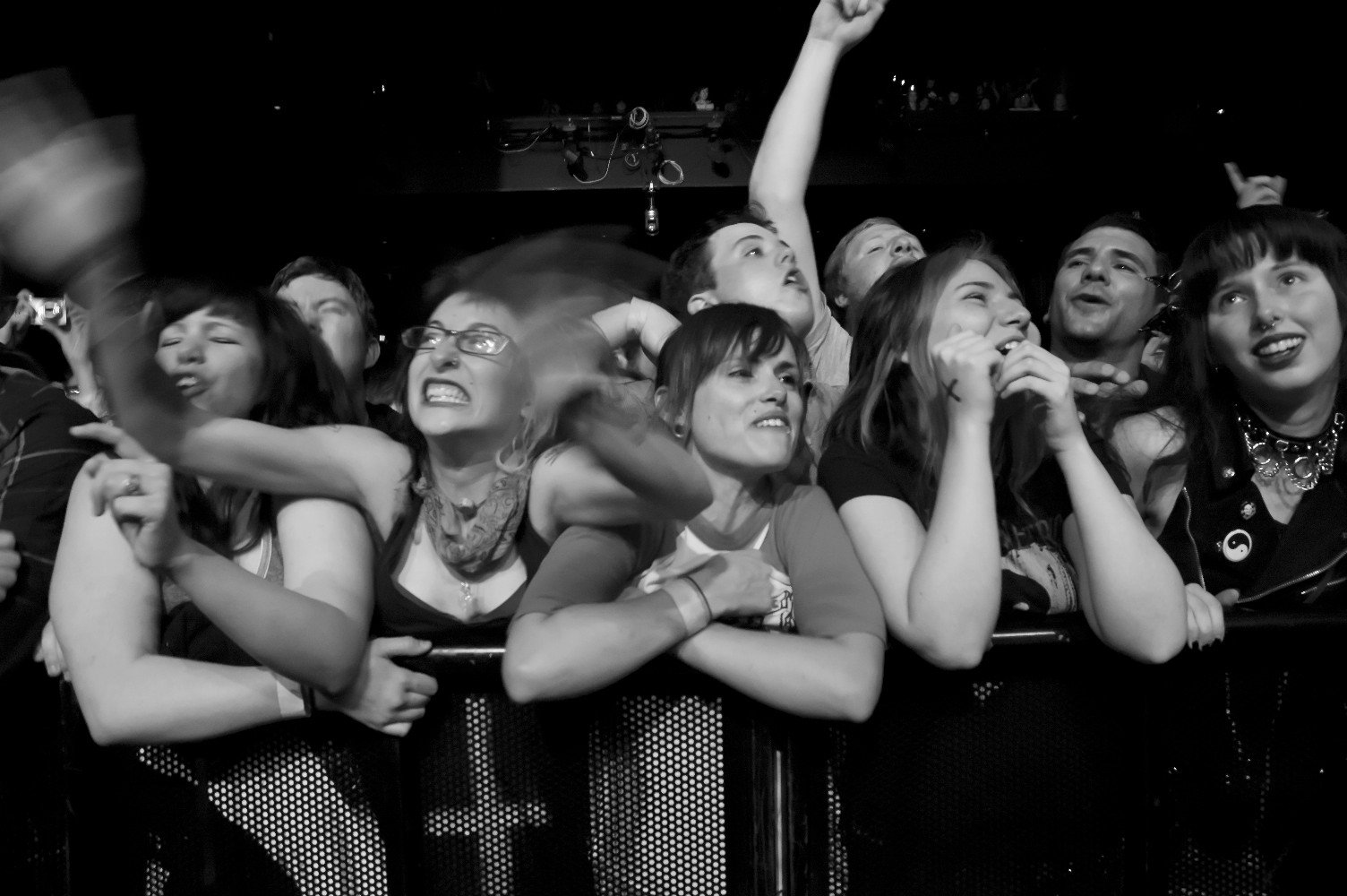 Black and white photo of the crowd cheering along the barricade for Alkaline Trio at House of Blue Boston
