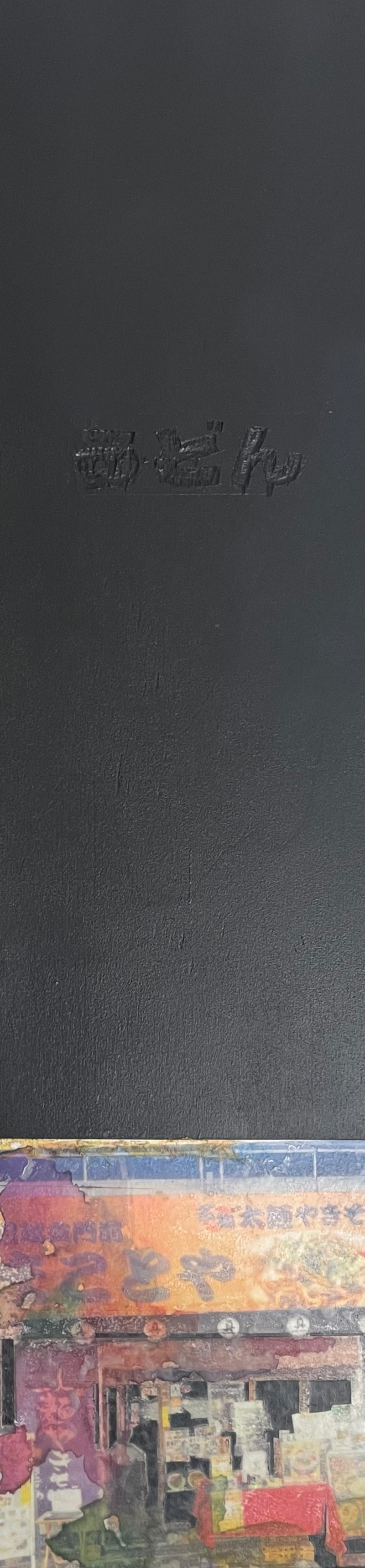 Close-up of a black surface with embossed Chinese characters, and a colorful collage of Chinese posters or advertisements at the bottom.