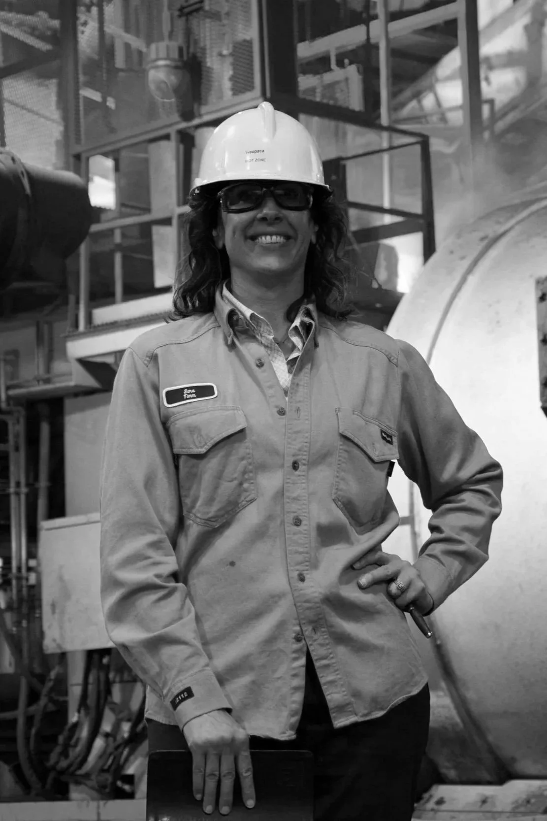 Sara Timm inside a metalcasting iron foundry wearing safety gear, a hard hat, and glasses in an industrial B2B manufacturing