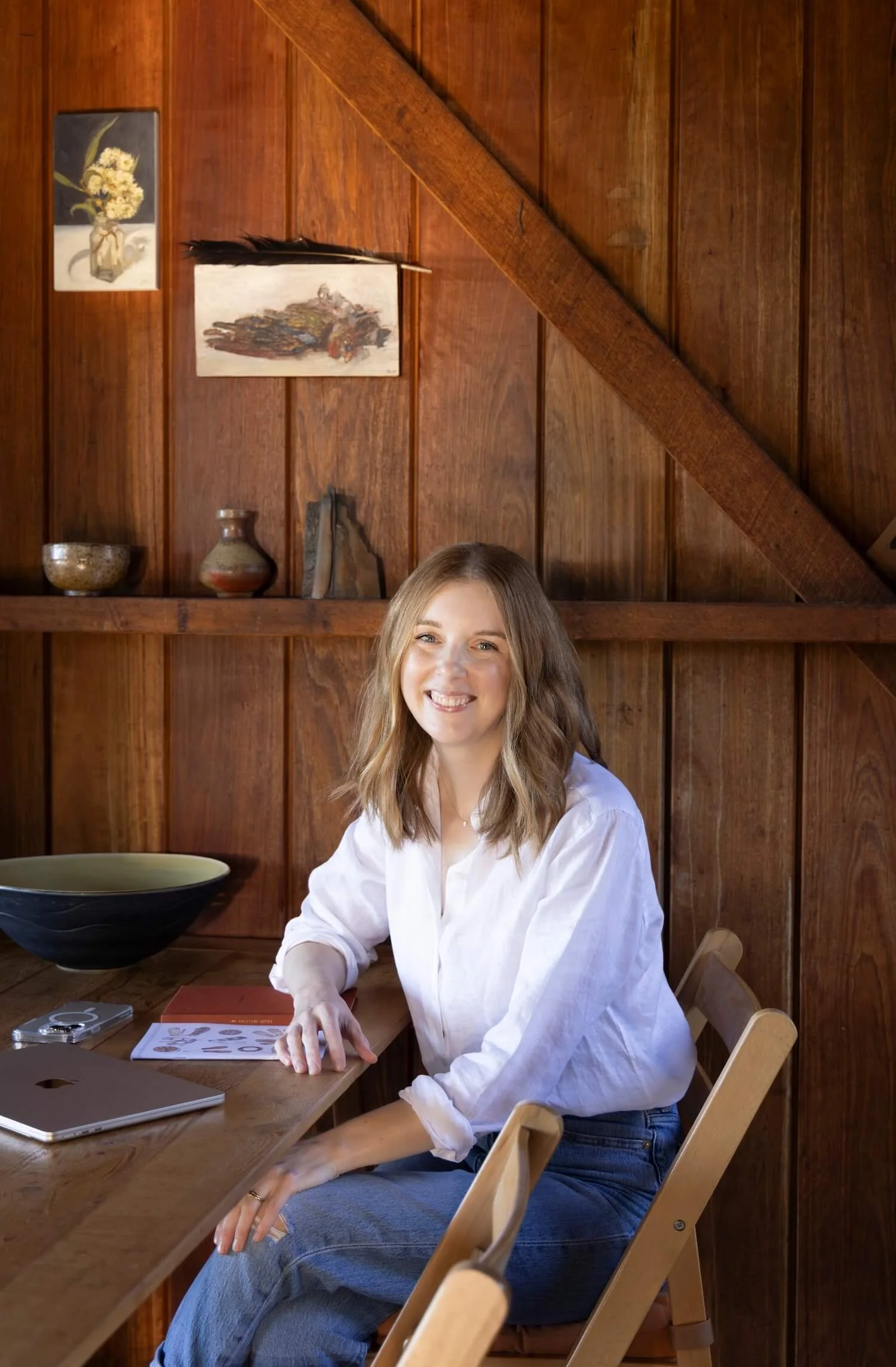 Dr Bea Bobbin, Canberra professional home organiser, seated at a wooden table with laptop and notebook