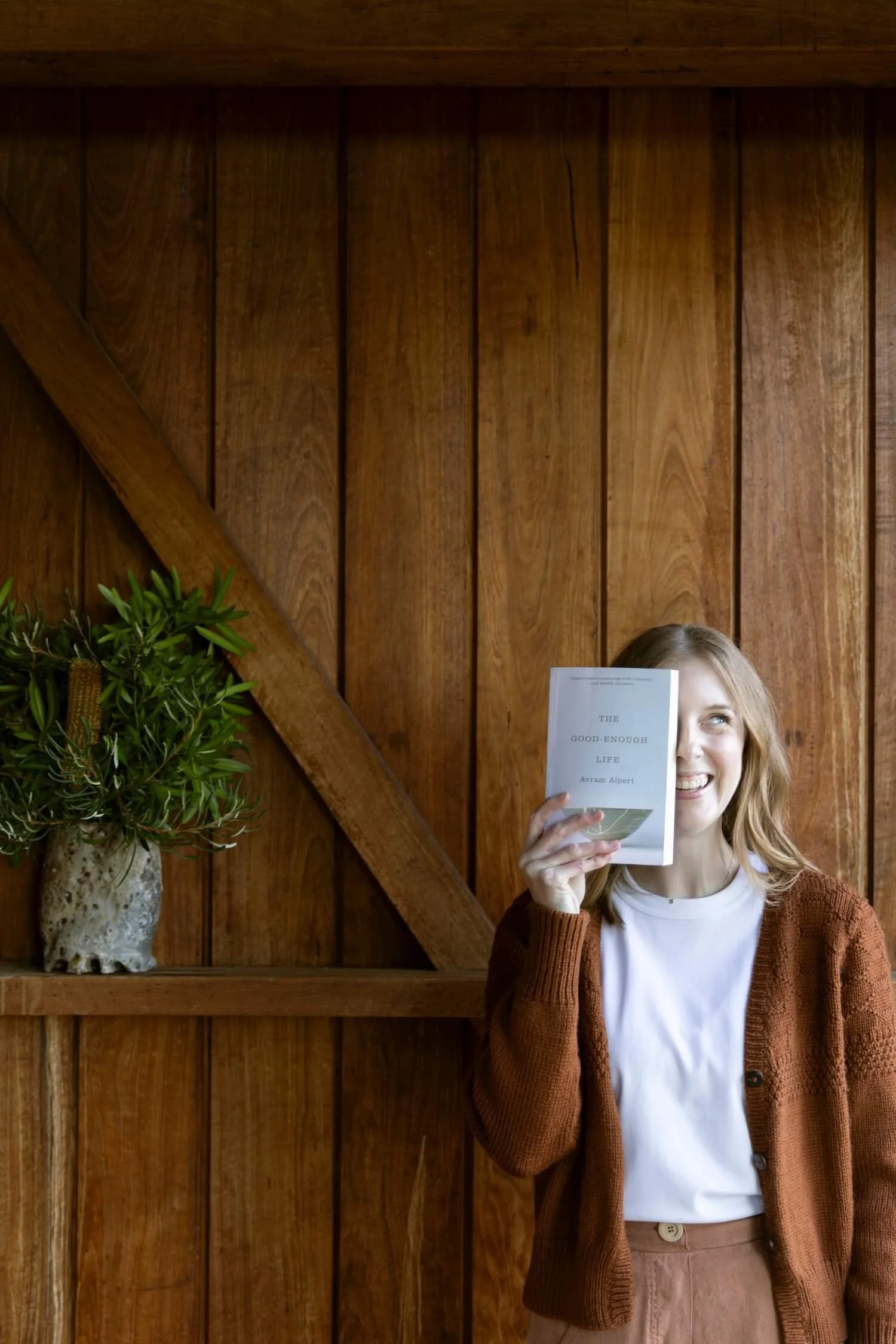 Canberra decluttering coach Bea Bobbins holding a book in front of one side of her face