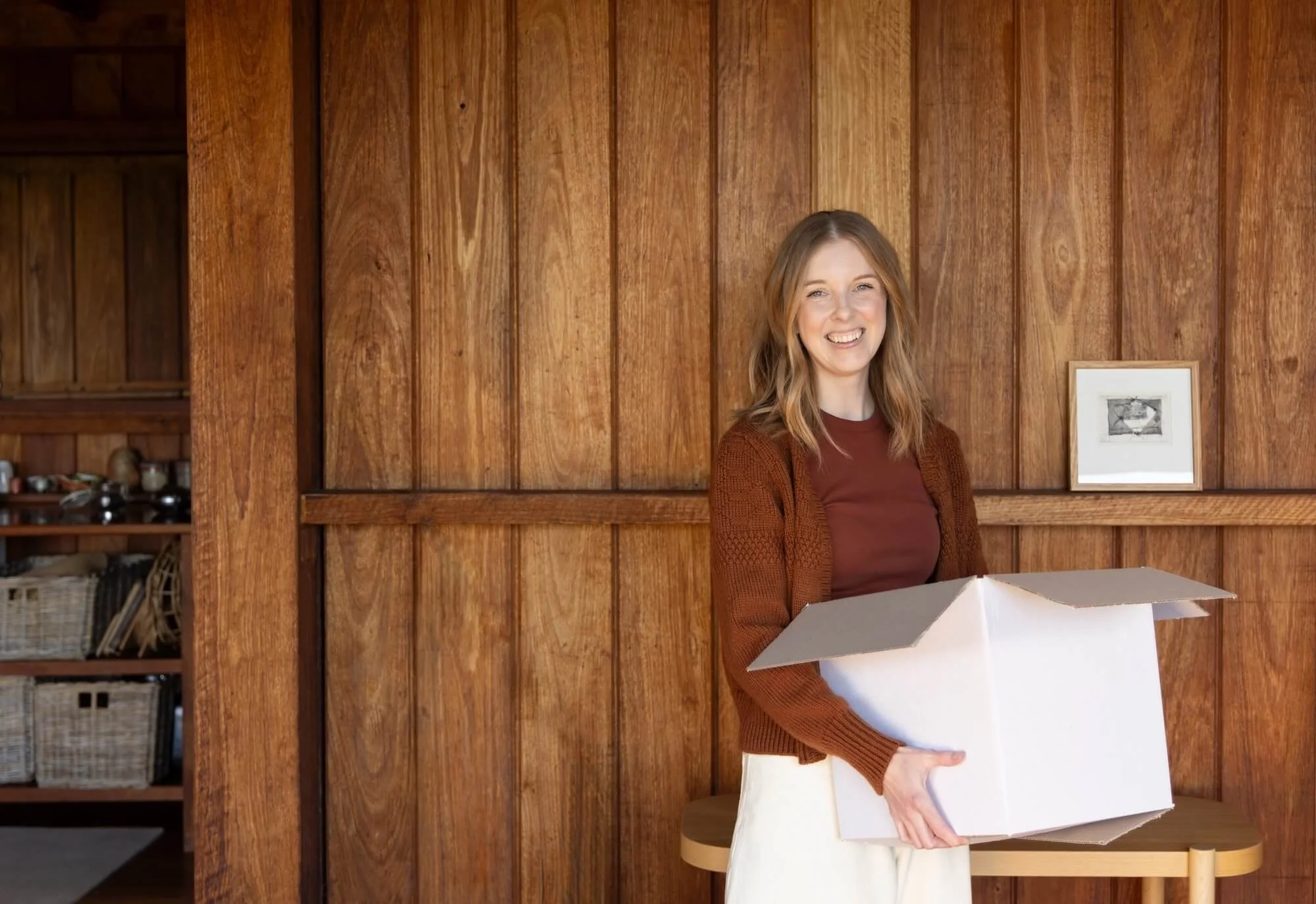 Dr Bea Bobbin holding an open packing box and smiling
