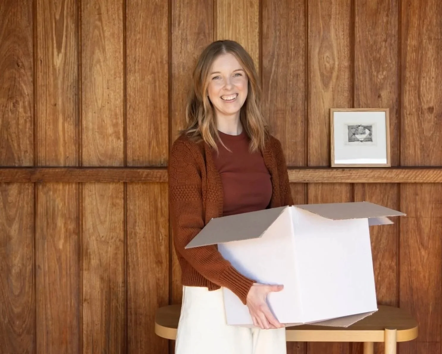 Dr Bea Bobbin, decluttering coach,  holding a white box packing box
