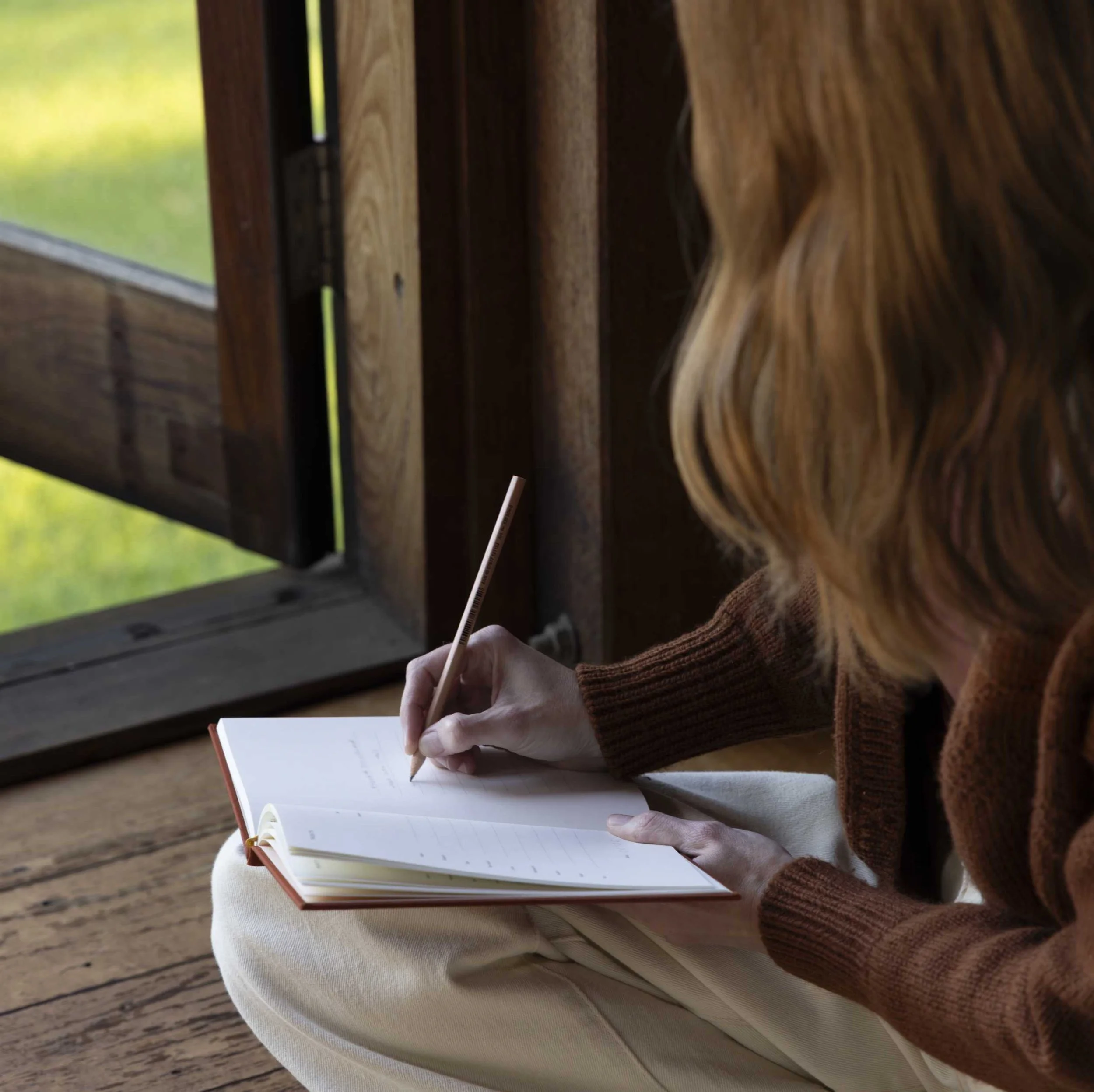 A close of of a woman's hand writing in a journal