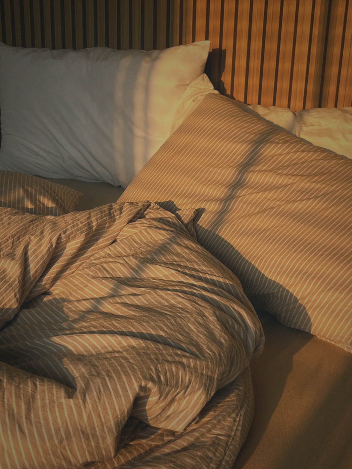 Cozy unmade bed space with filtered morning light