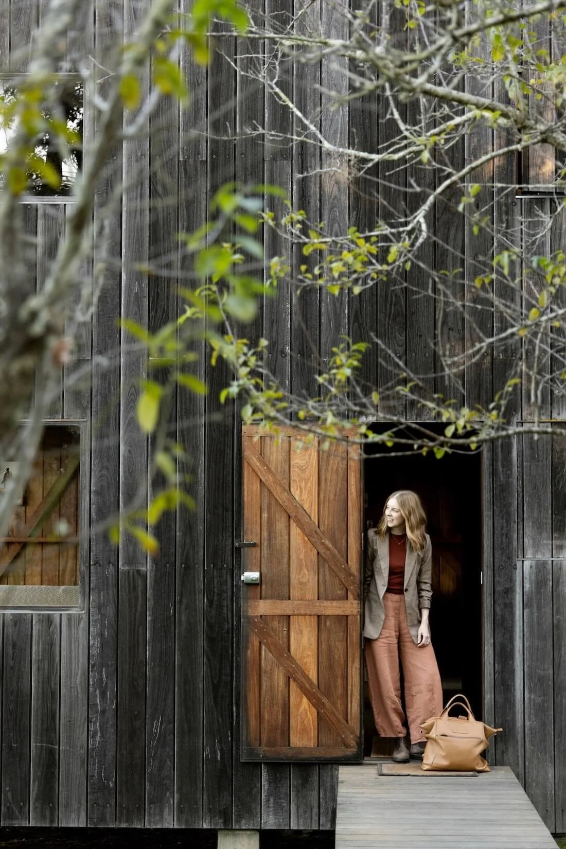 Dr Bea Bobbin standing in the doorway of a weathered wooden barn.