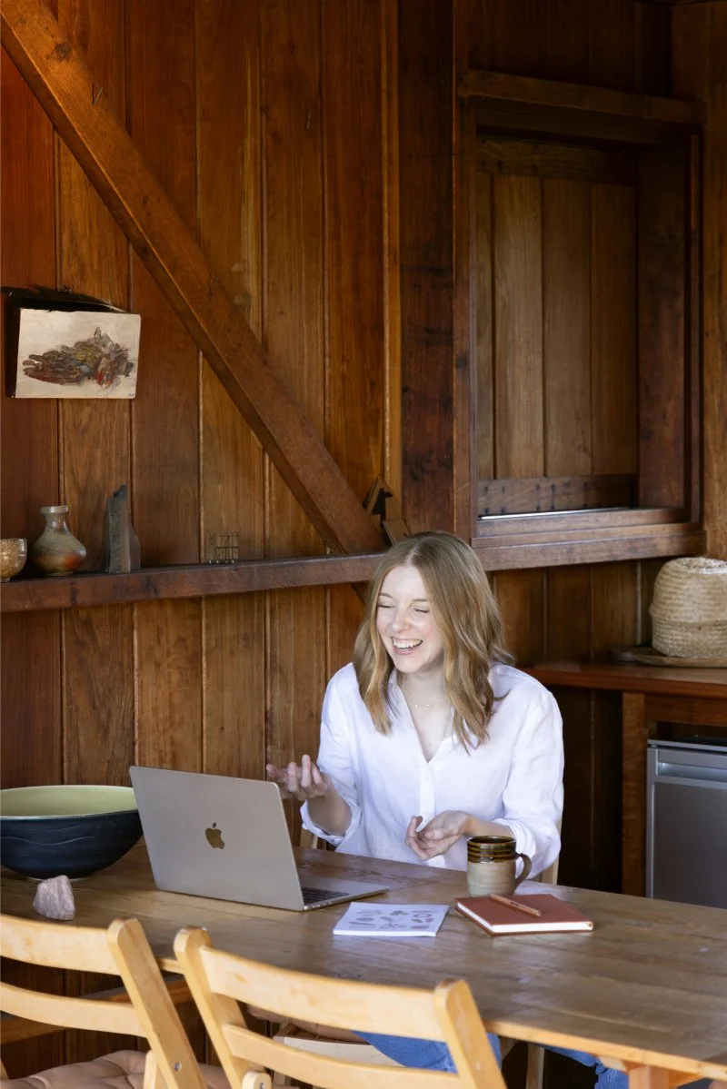 Woman on a video call getting help with why her house is always messy, laptop open at her dining table