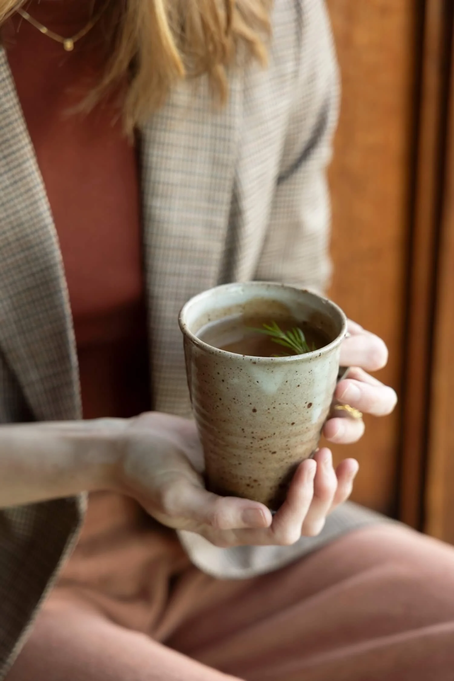Close-up of hands cradling a handmade stoneware mug
