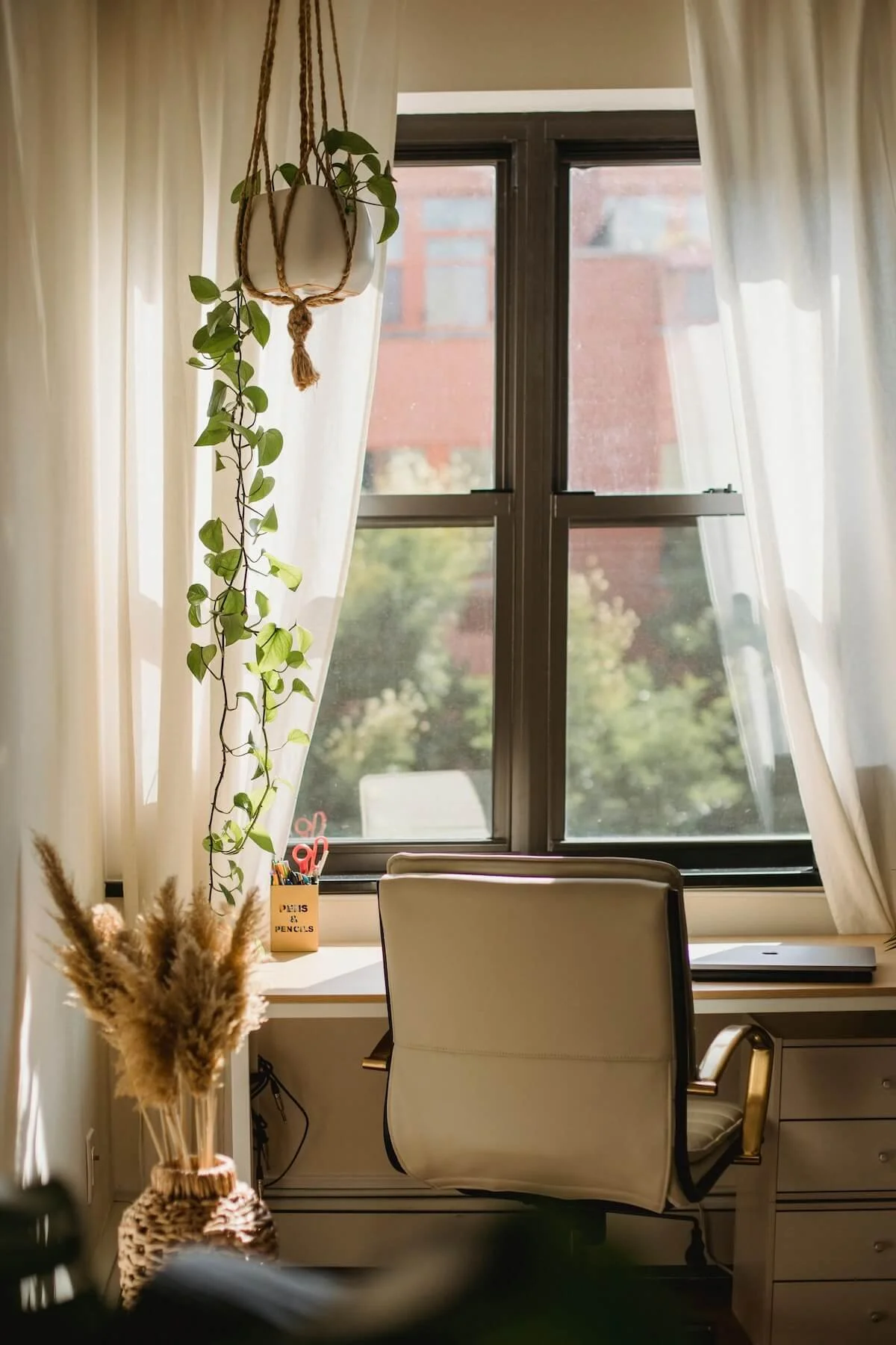 Bright home corner with a hanging macramé plant and warm natural light