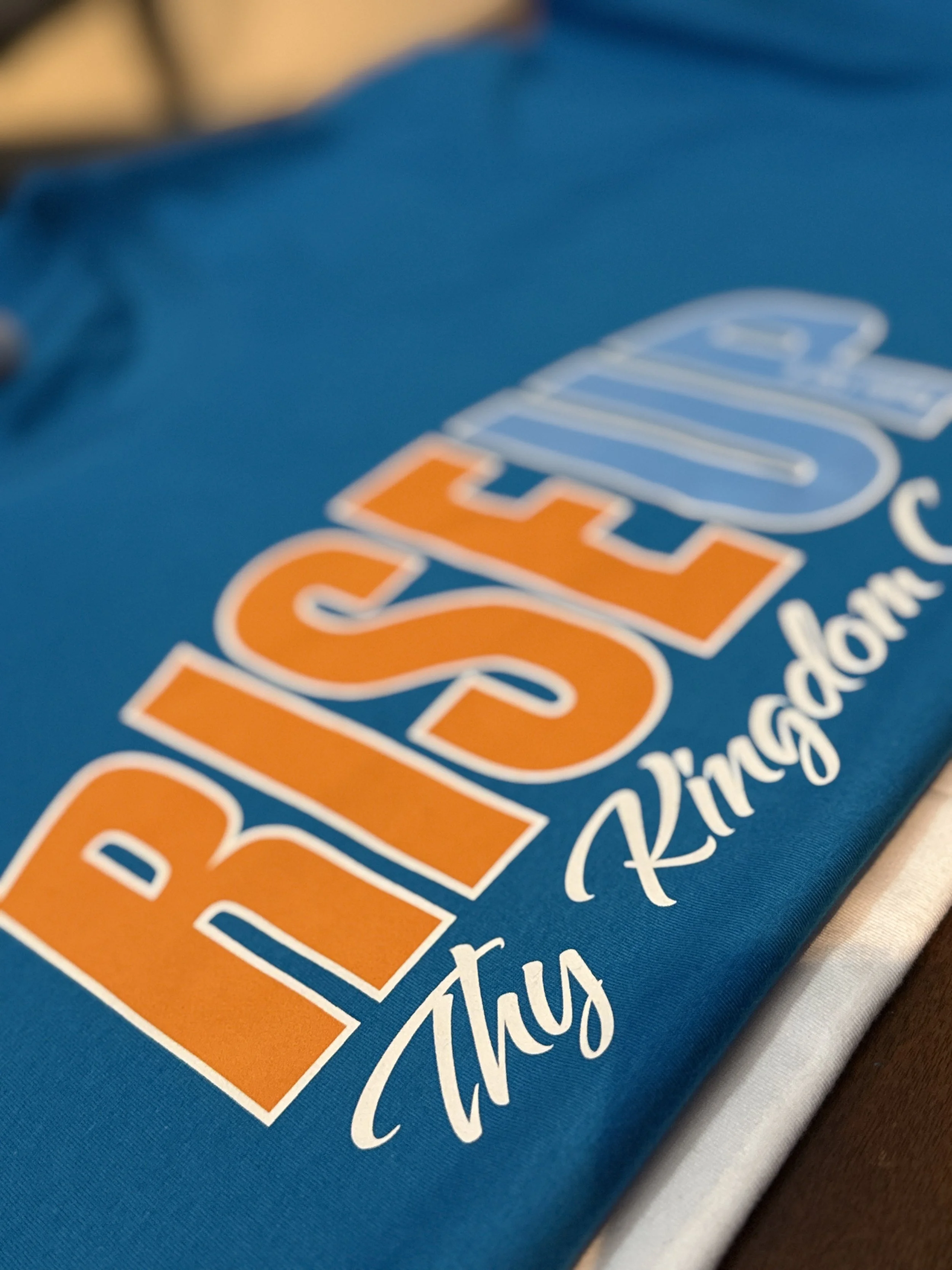 Close-up of a blue fabric with colorful text including orange, white, and blue lettering.