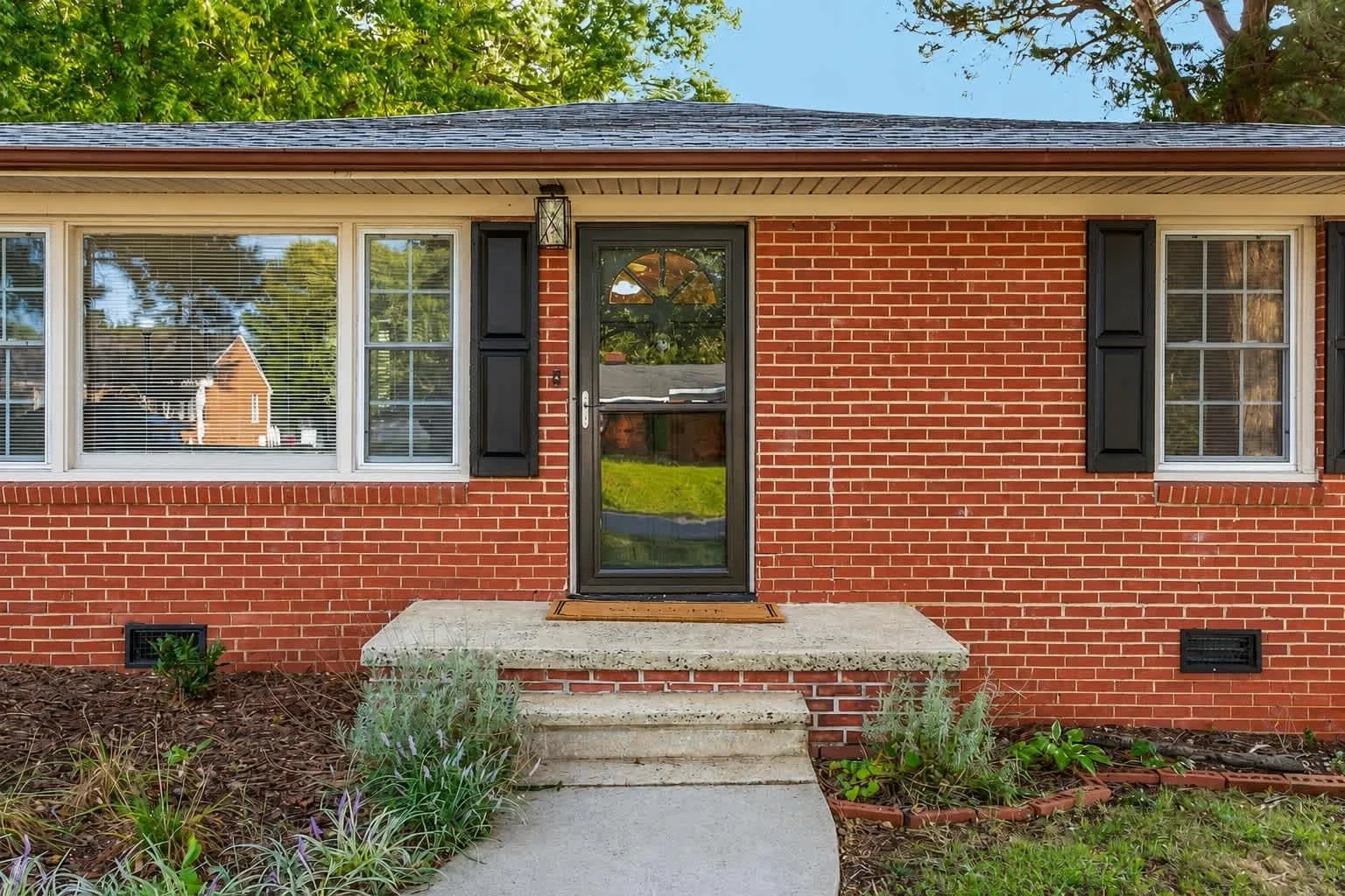 Front entrance of a three-bedroom brick short-term rental in Burlington, North Carolina