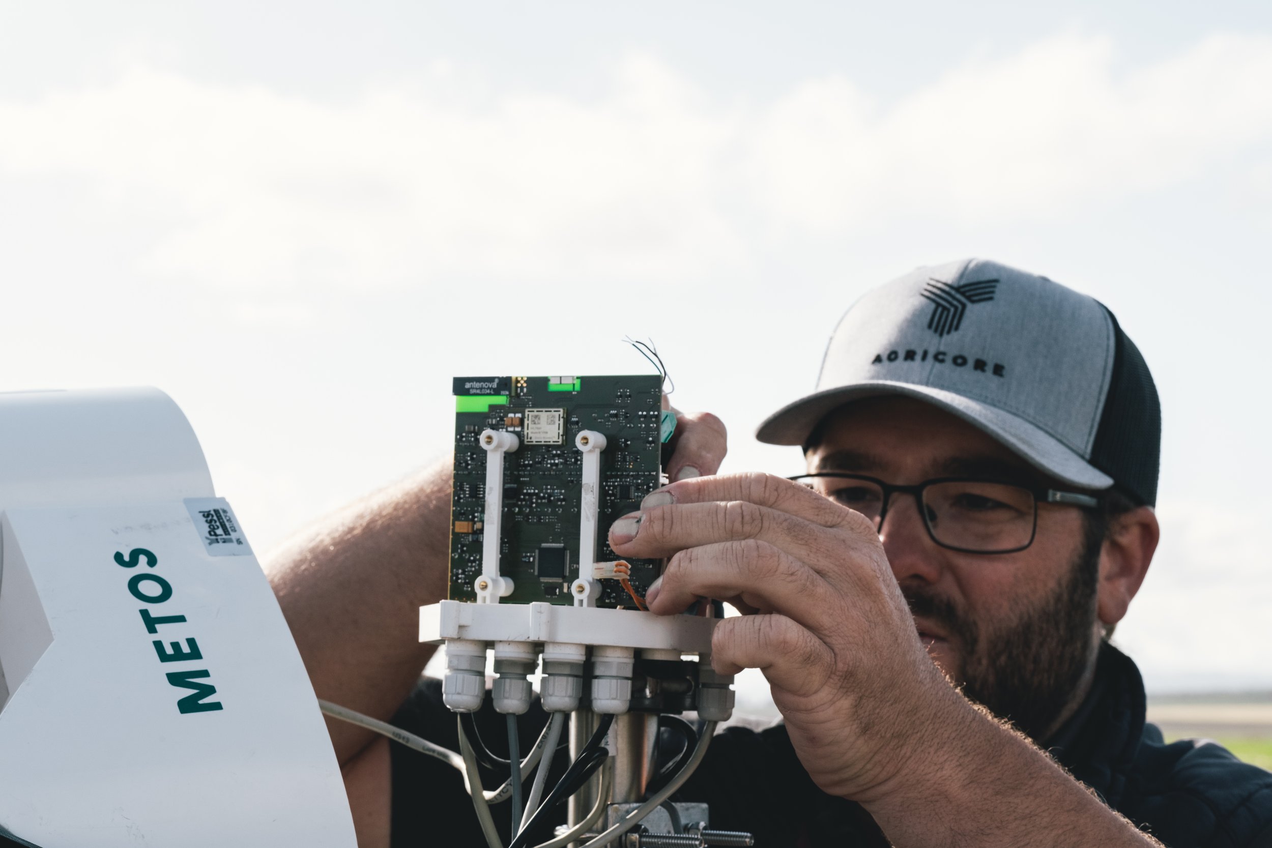 Agricore technician servicing precision agriculture equipment in the field.