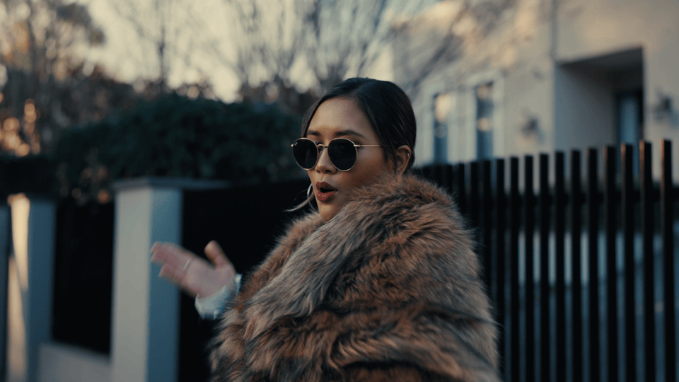 A woman wearing sunglasses and a fur coat. Melbourne-based R&B music video. Music video with Melbourne-based singer Alisya Rae. Materialists inspired music video, girlboss, feminist, romance, love.