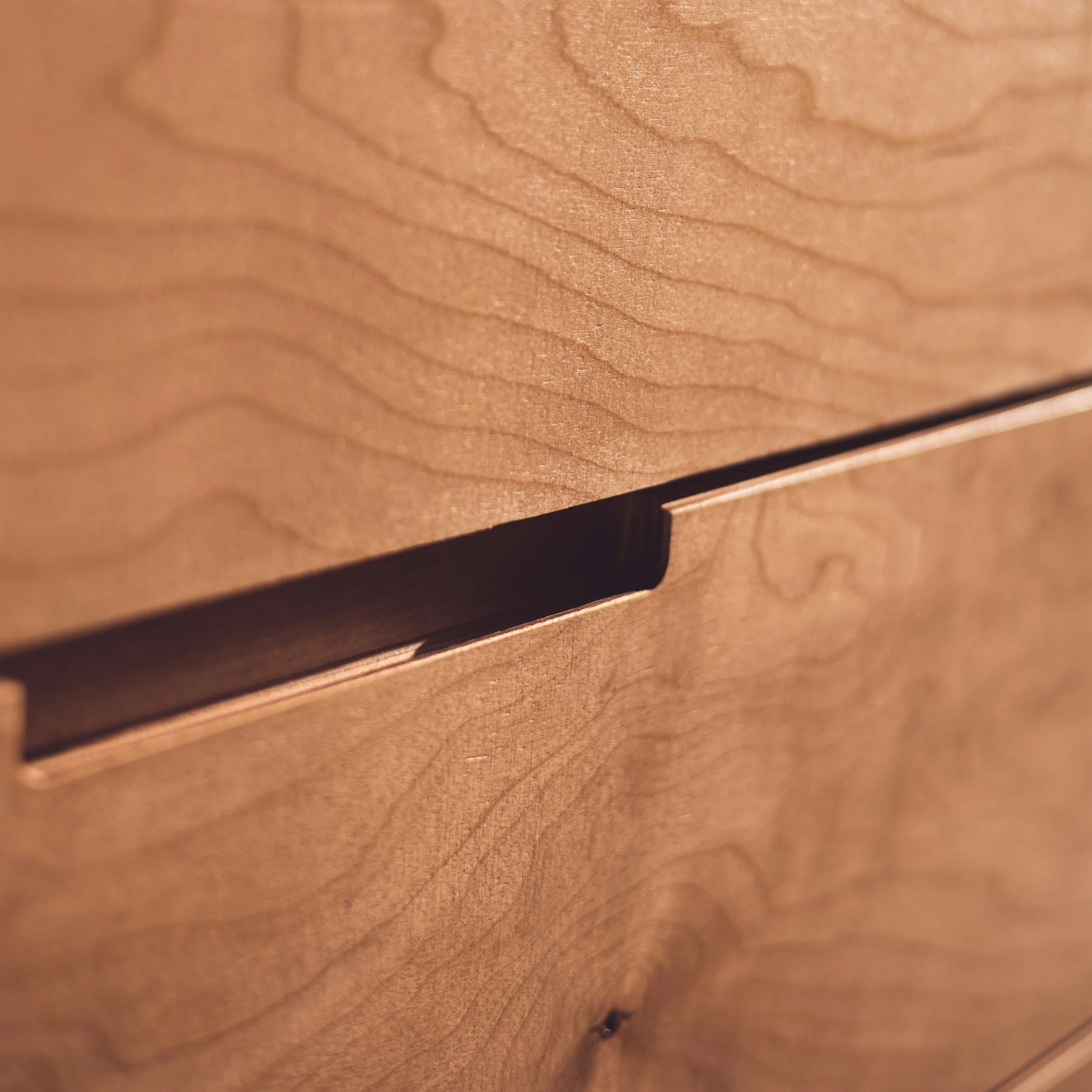 Close-up of a wooden surface with visible grain and a small dark spot near the bottom.