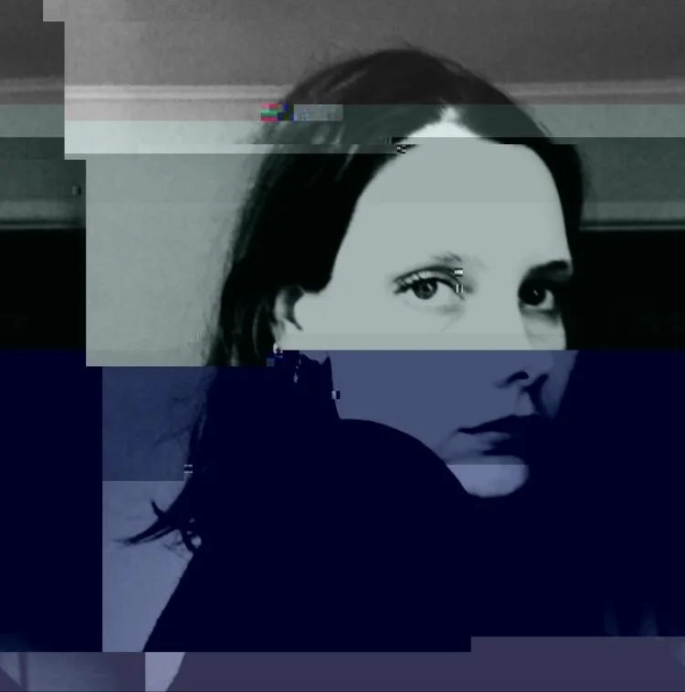 A woman with dark hair and piercing eyes, with a digital glitch effect overlay.
