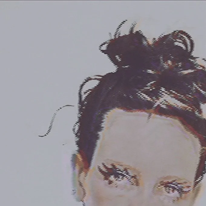 Artist with messy bun and creative makeup.