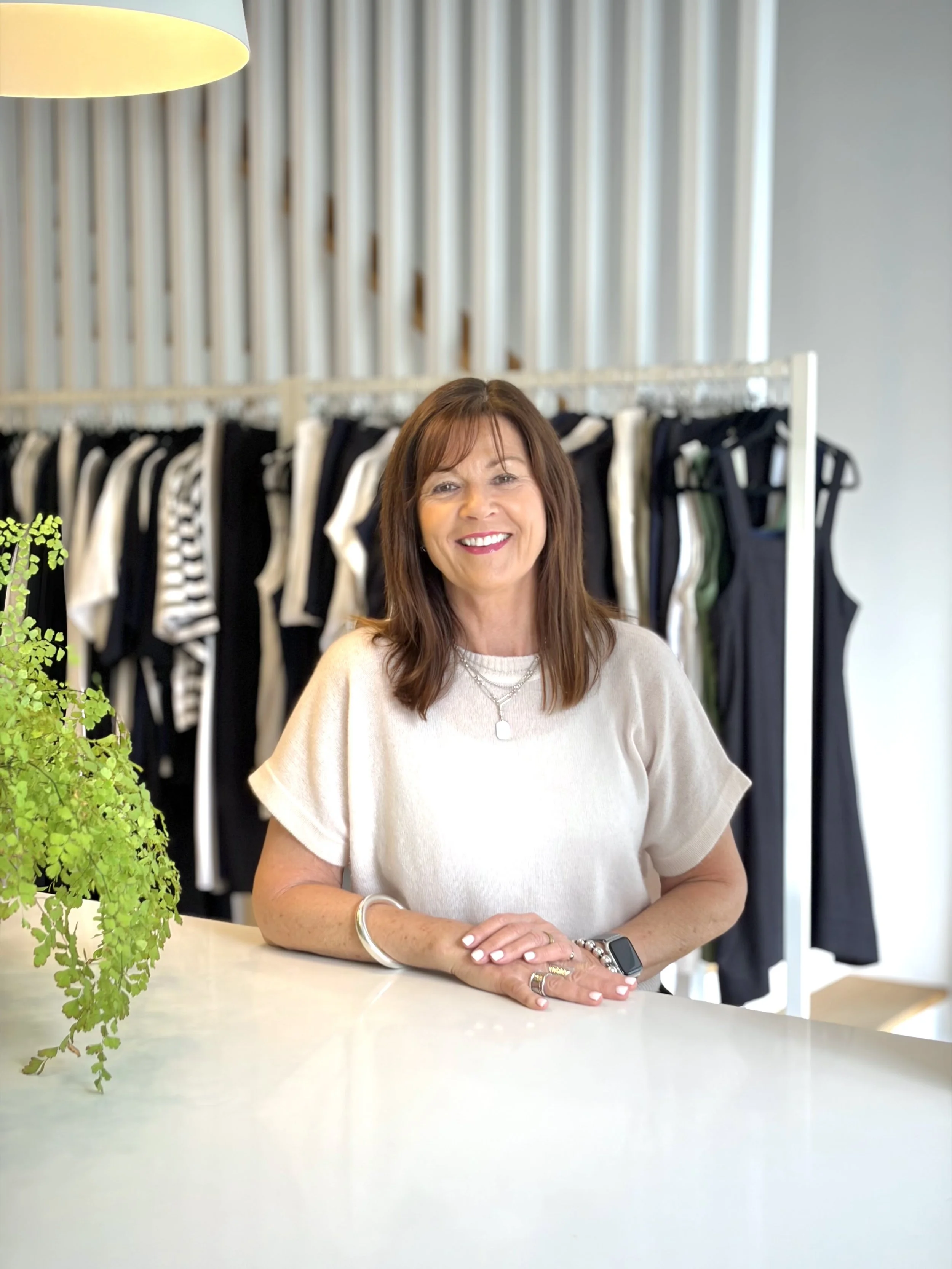 Jen, merchandising and stockist support at Louise Wilkinson Agencies, smiling in the LWA Brisbane showroom surrounded by boutique fashion stock.  Jen | Merchandising & Stockist Support — Louise Wilkinson Agencies