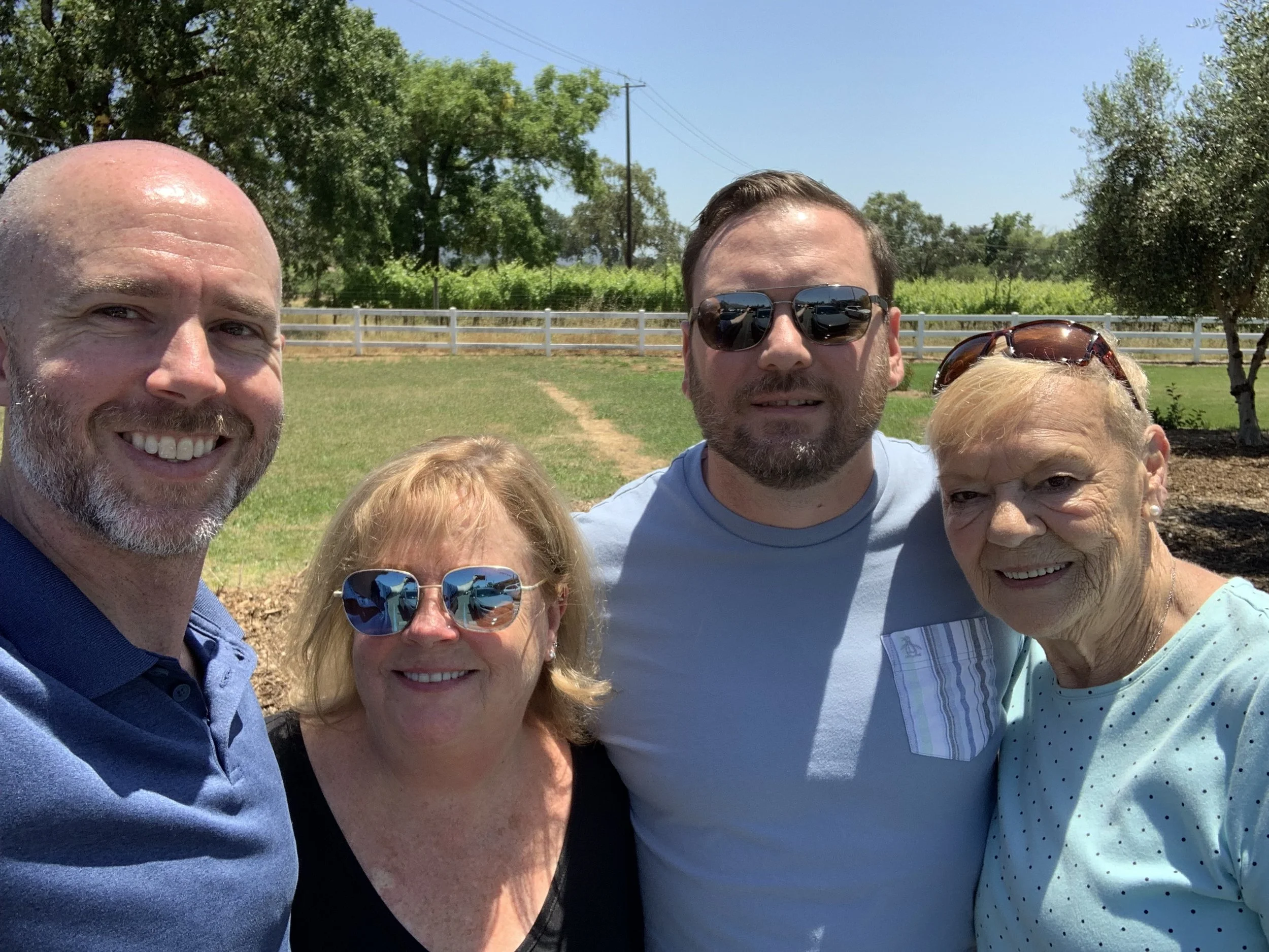 Michael, his husband Daniel and their mothers pose take a selfie at a park
