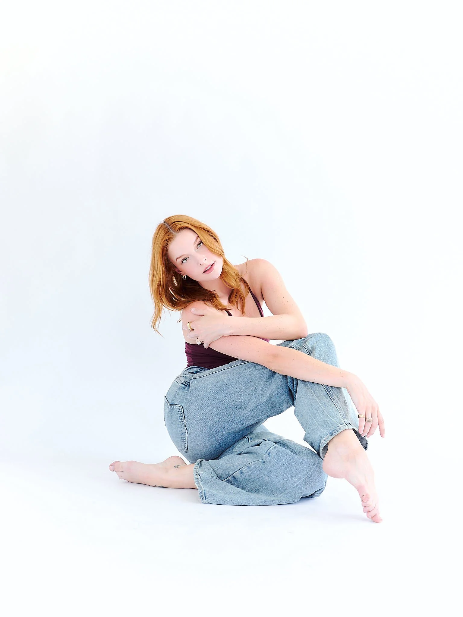 portrait of red head woman in front of off white backdrop for her model development photography session in LA California