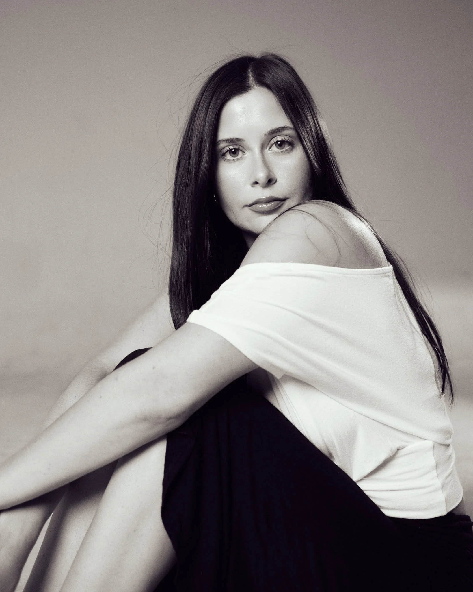 Black and white editorial portrait of seated female model