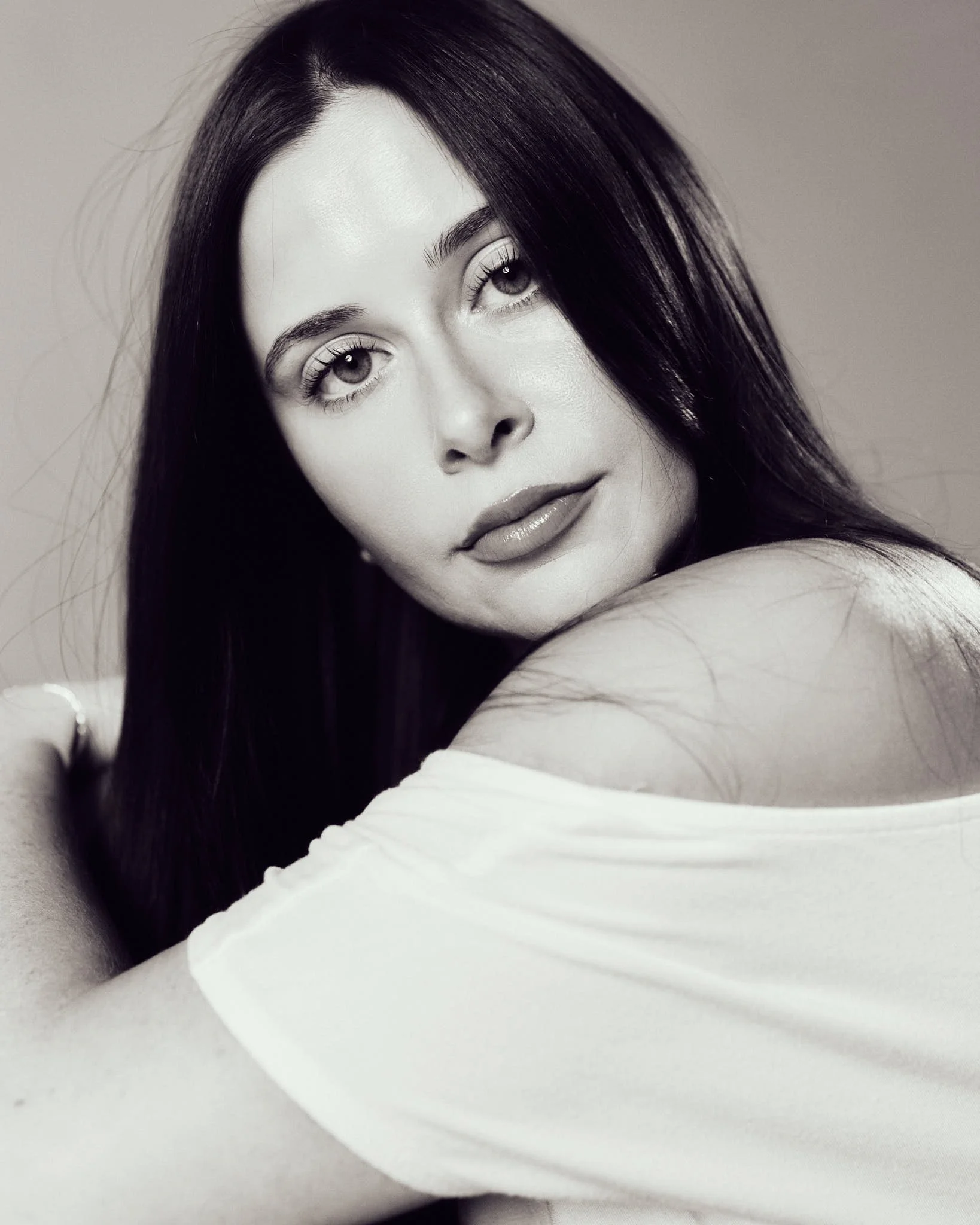 Black-and-white close-up beauty portrait of female model looking over her shoulder during a model development session.
