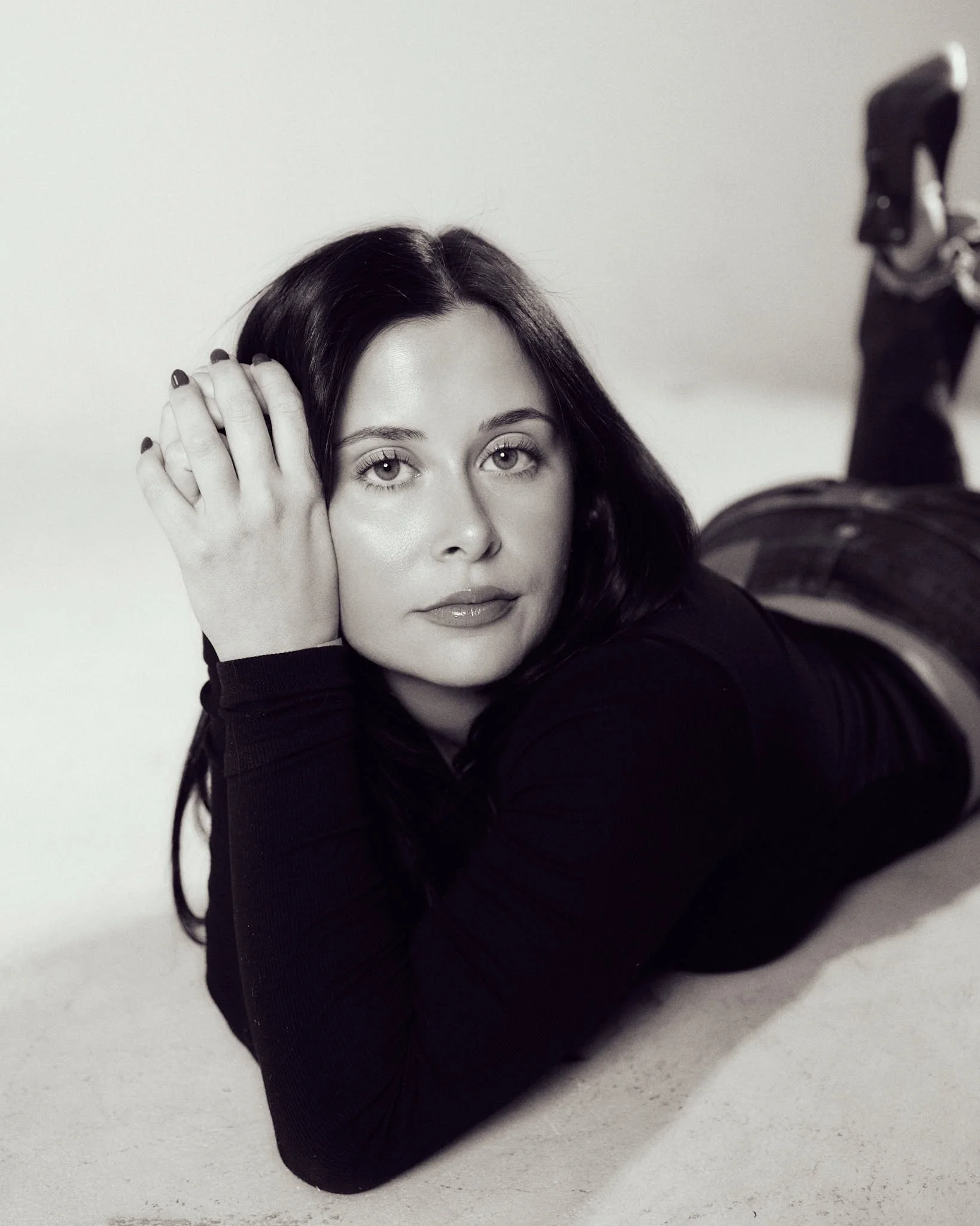 Black-and-white close-up portrait of female model reclining during a Denver model development photoshoot.
