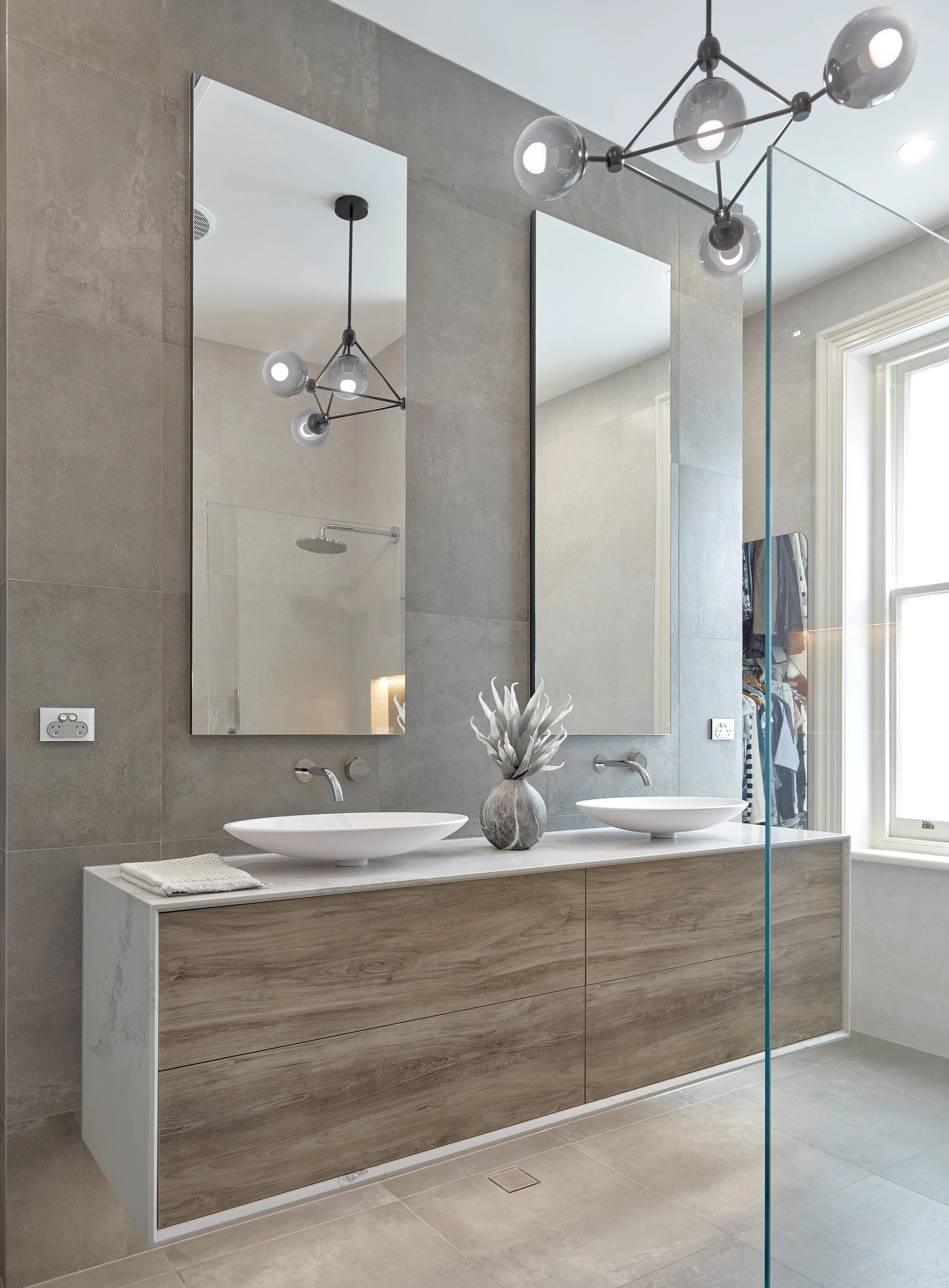 Modern bathroom with a custom-made vanity wrapped in Caesarstone benchtop surround, and new age veneer grain matched drawers