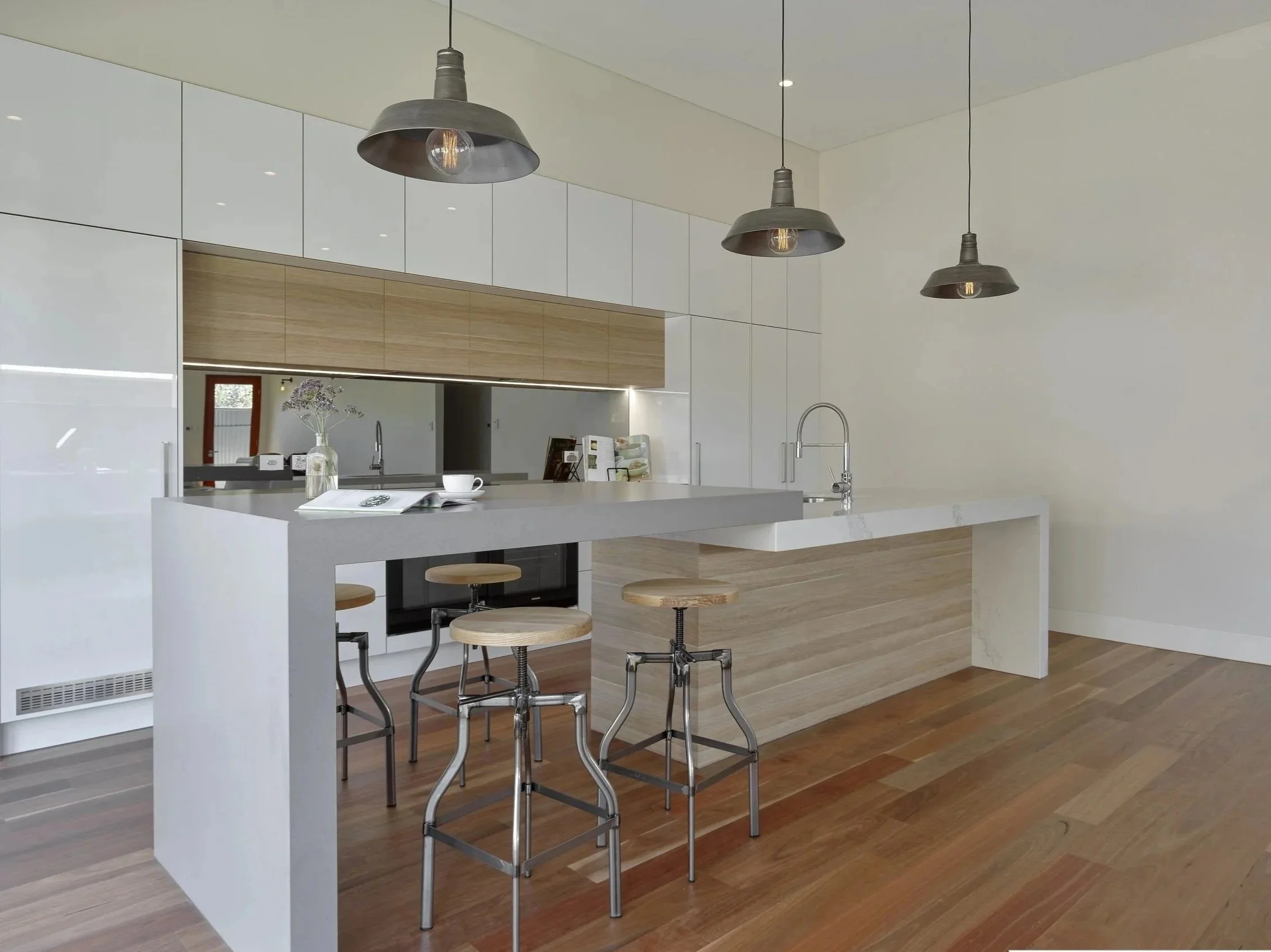 Modern industrial kitchen with raised bench seating area, Butlers Pantry and Laundry hidden behind via the two right hand doors.