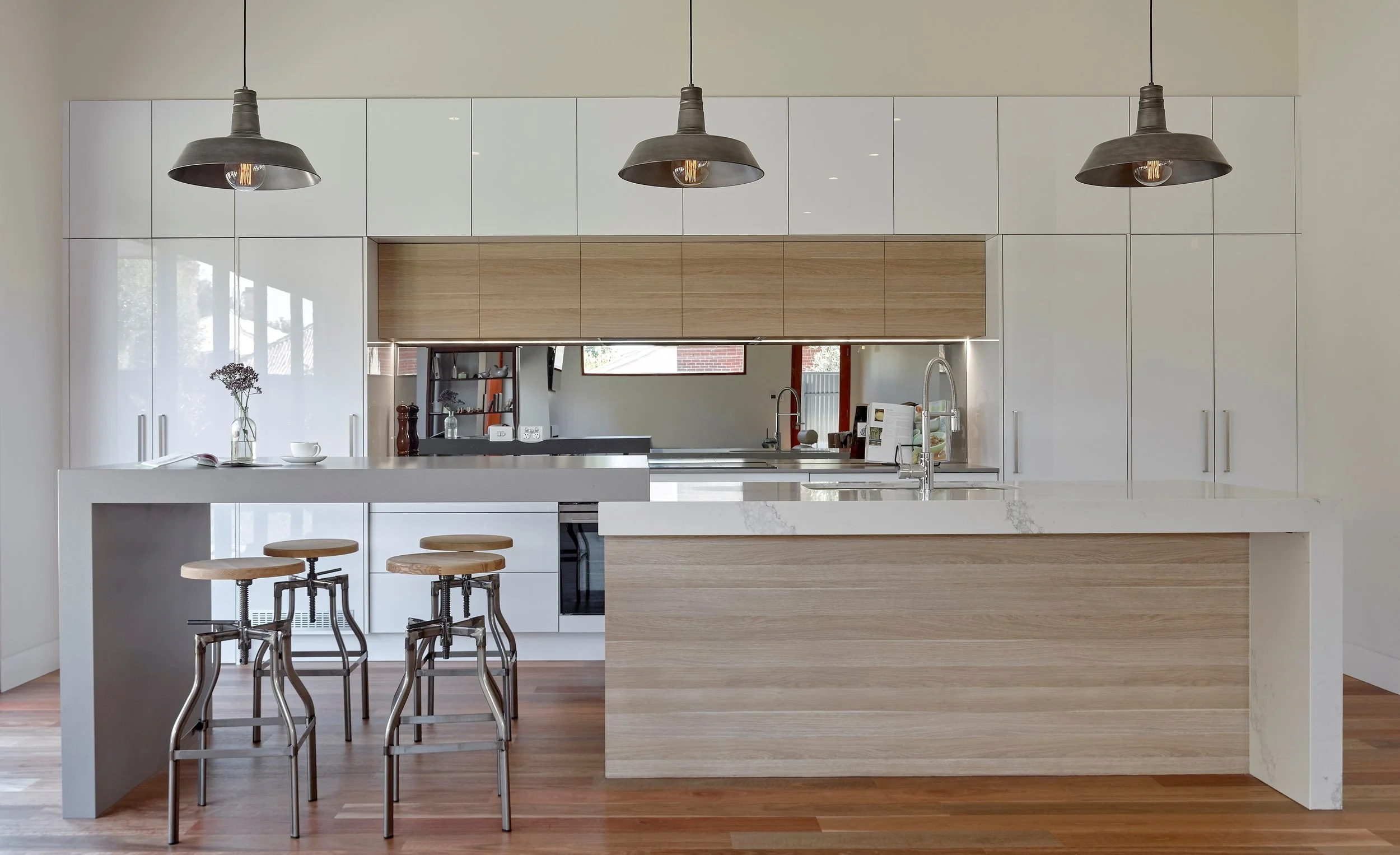 Modern Industrial kitchen Mirrored splashback, hidden Laundry to the Left and hidden Pantry to the right behind integrated bifold doors