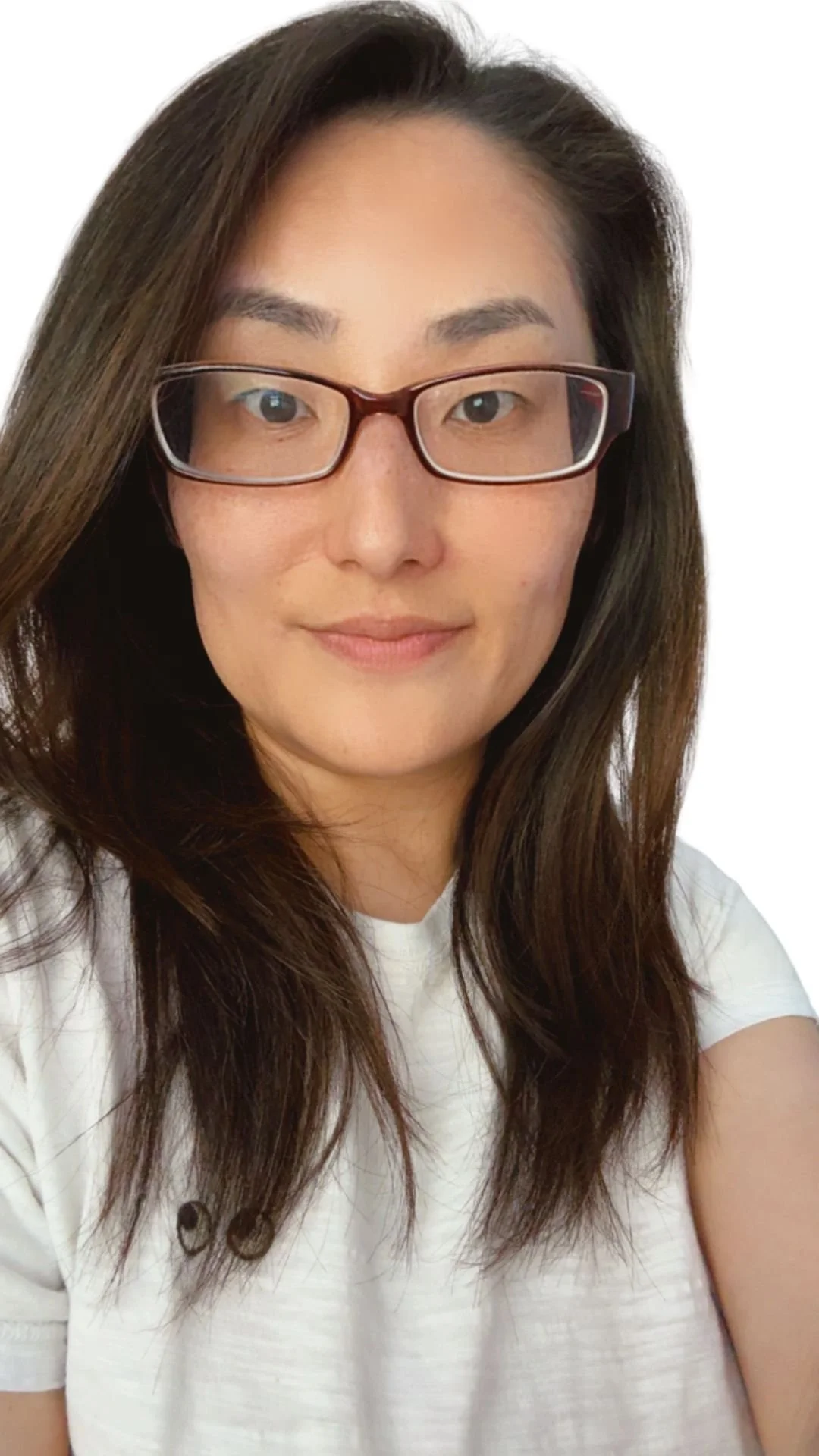 A woman with long brown hair and glasses, wearing a white shirt, smiling gently against a white background, who is a founder of SOEL counselling.