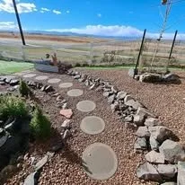 Stone pathway with circular stepping stones bordered by rocks in an outdoor garden or yard