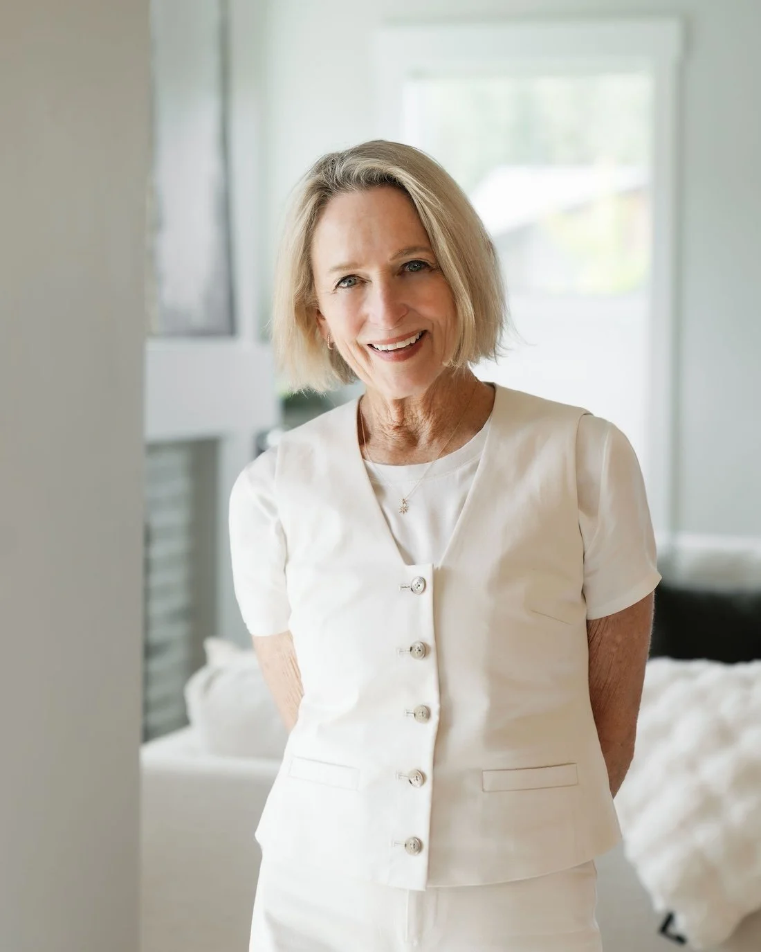 Older woman with blonde hair smiling in bright home listing photo for Bend Oregon Real Estate Agency.