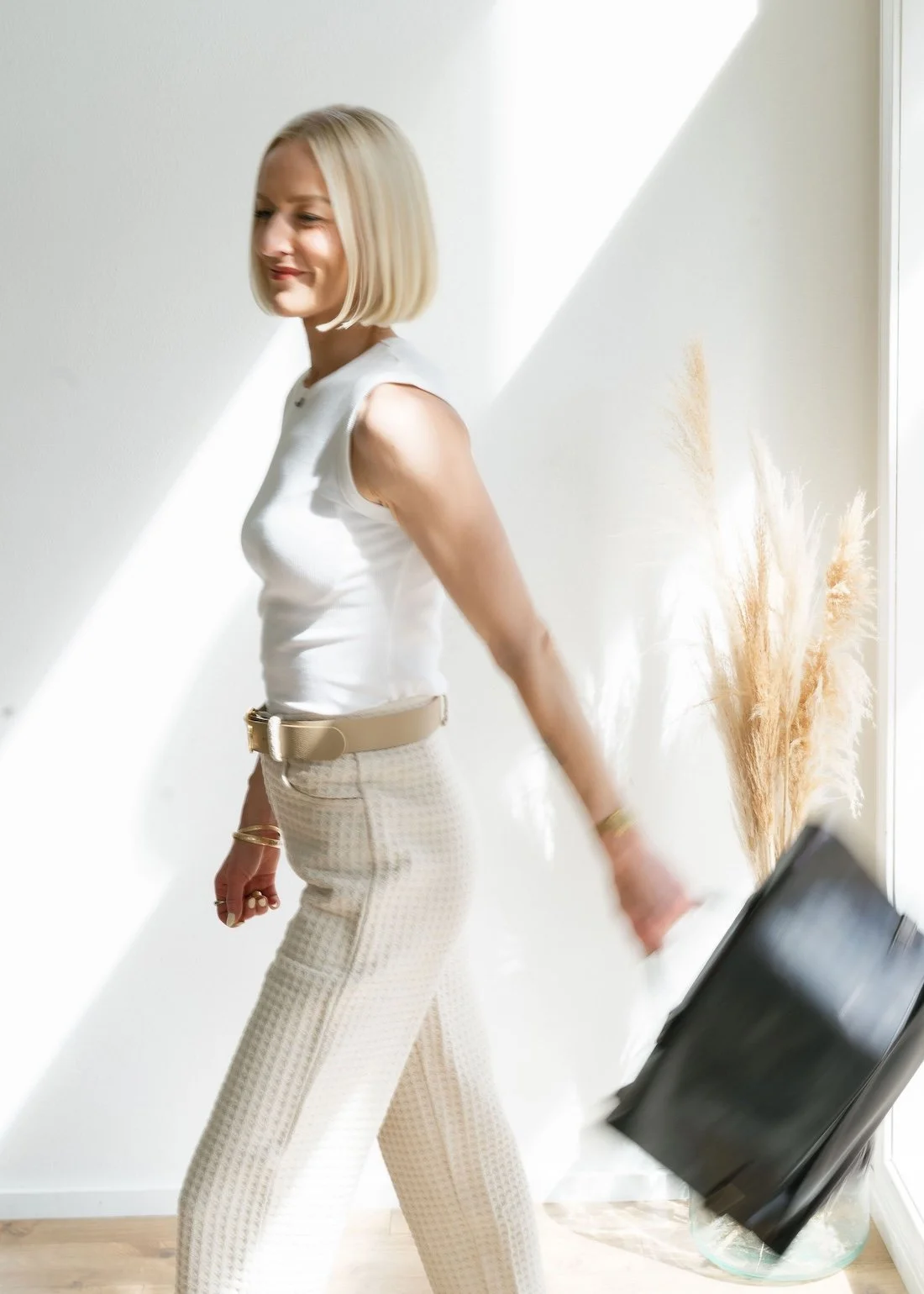 A woman with blonde hair in neutral colors carrying a black bag is Chelsea Ortega, real estate agent in Bend Oregon.