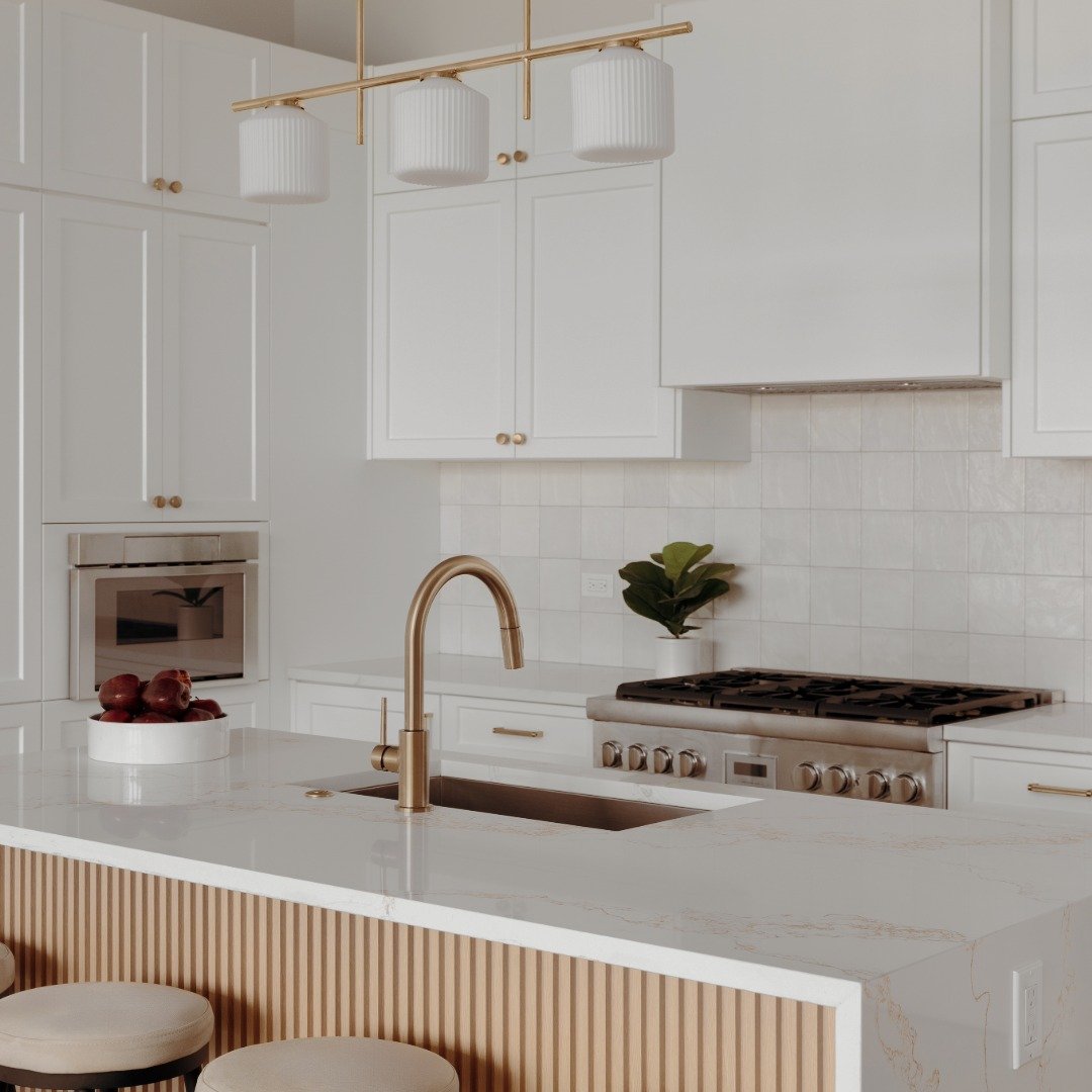 Modern white kitchen with gold accents, a marble countertop island a listing photo for a Bend Real Estate Agency.