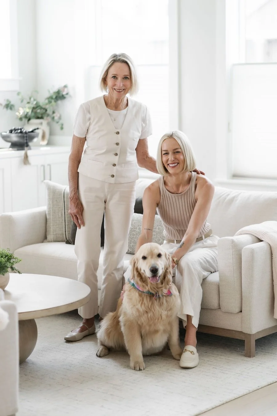 Two women with a golden retriever, in a bright, modern living room that is a home listing for Bend Oregon Real Estate Market.