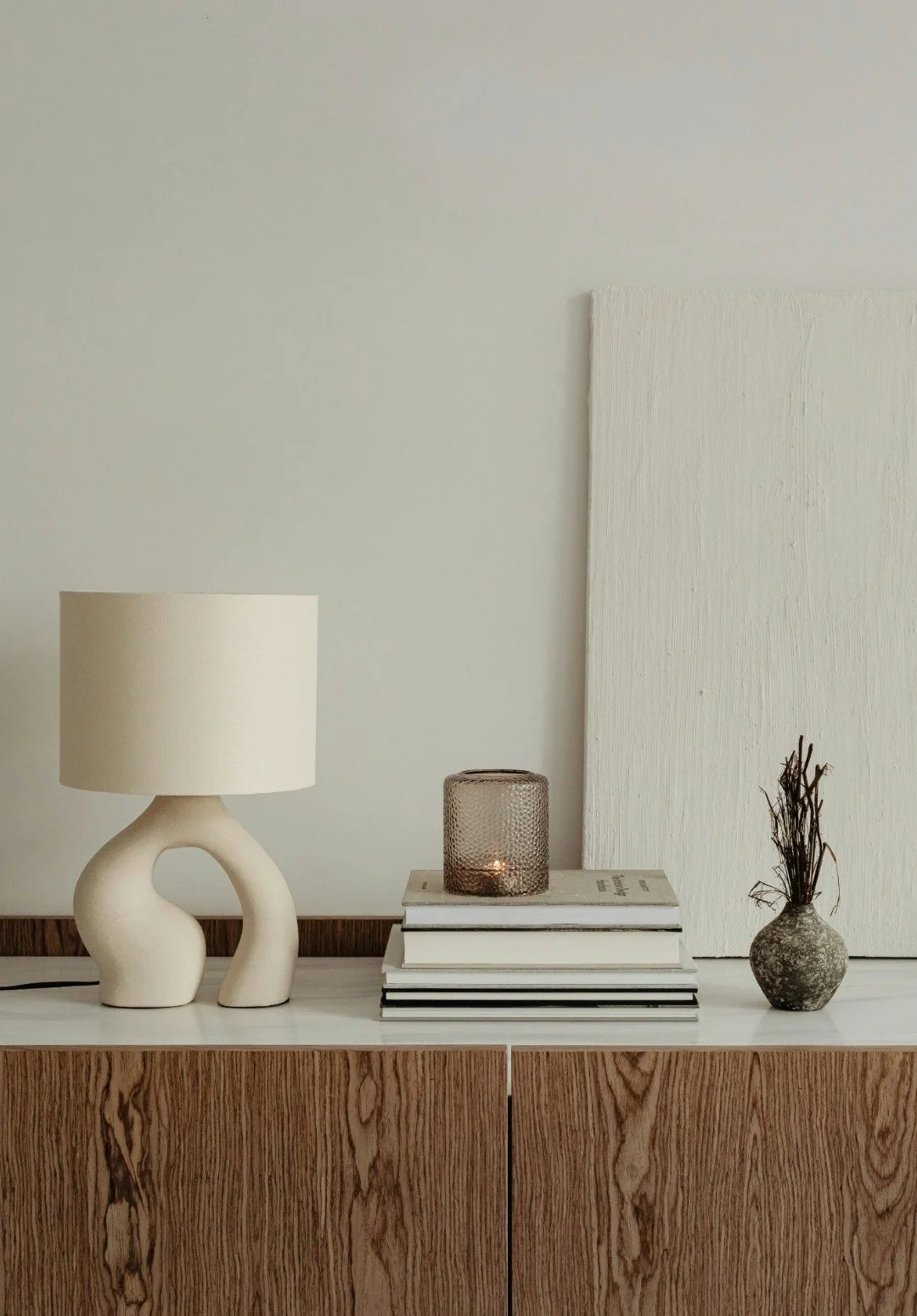 A side table with a light, books and decor