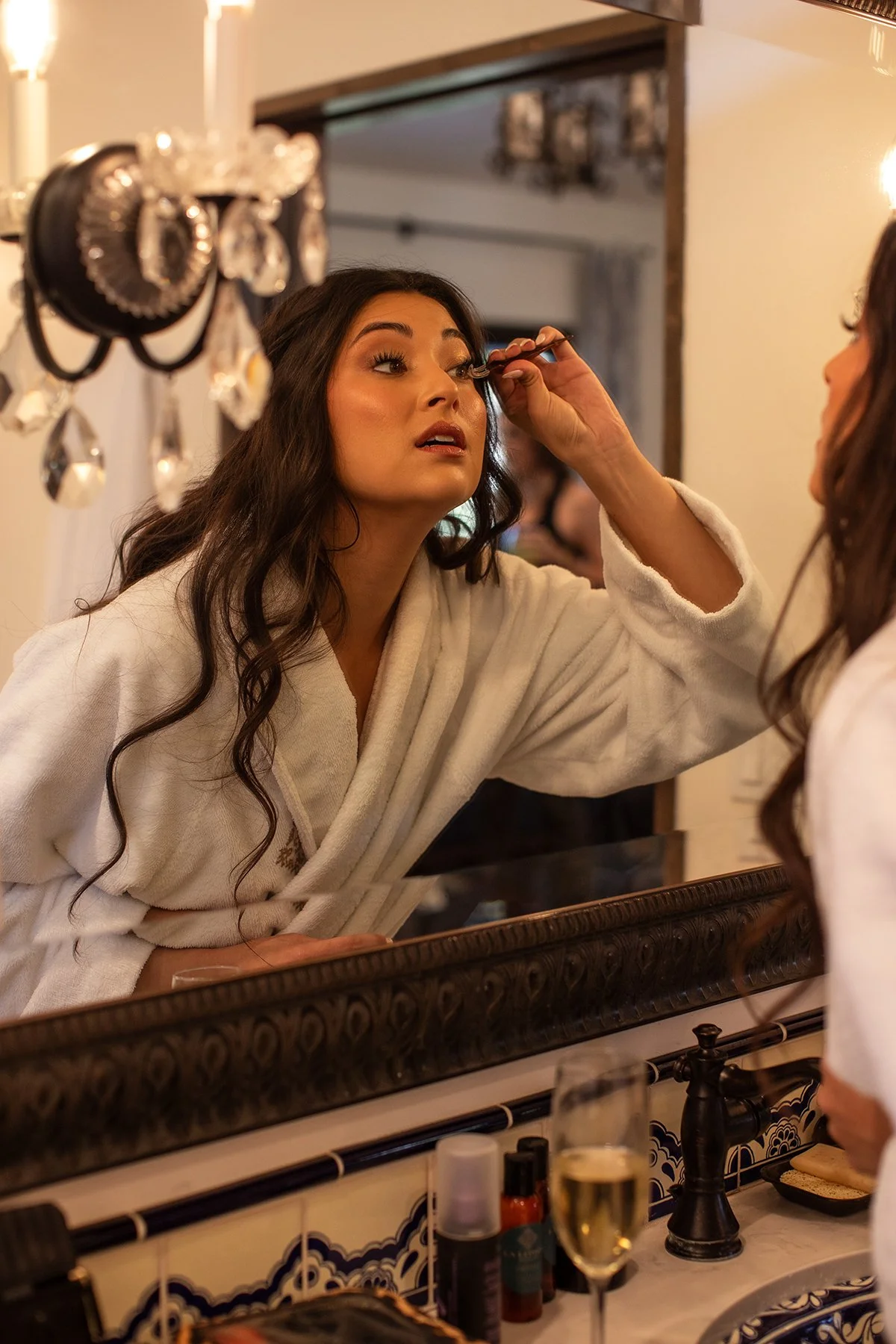 Bride getting ready in a white robe before her wedding ceremony.
