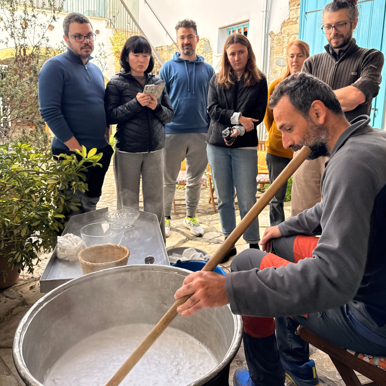 people watching a man making halloumi