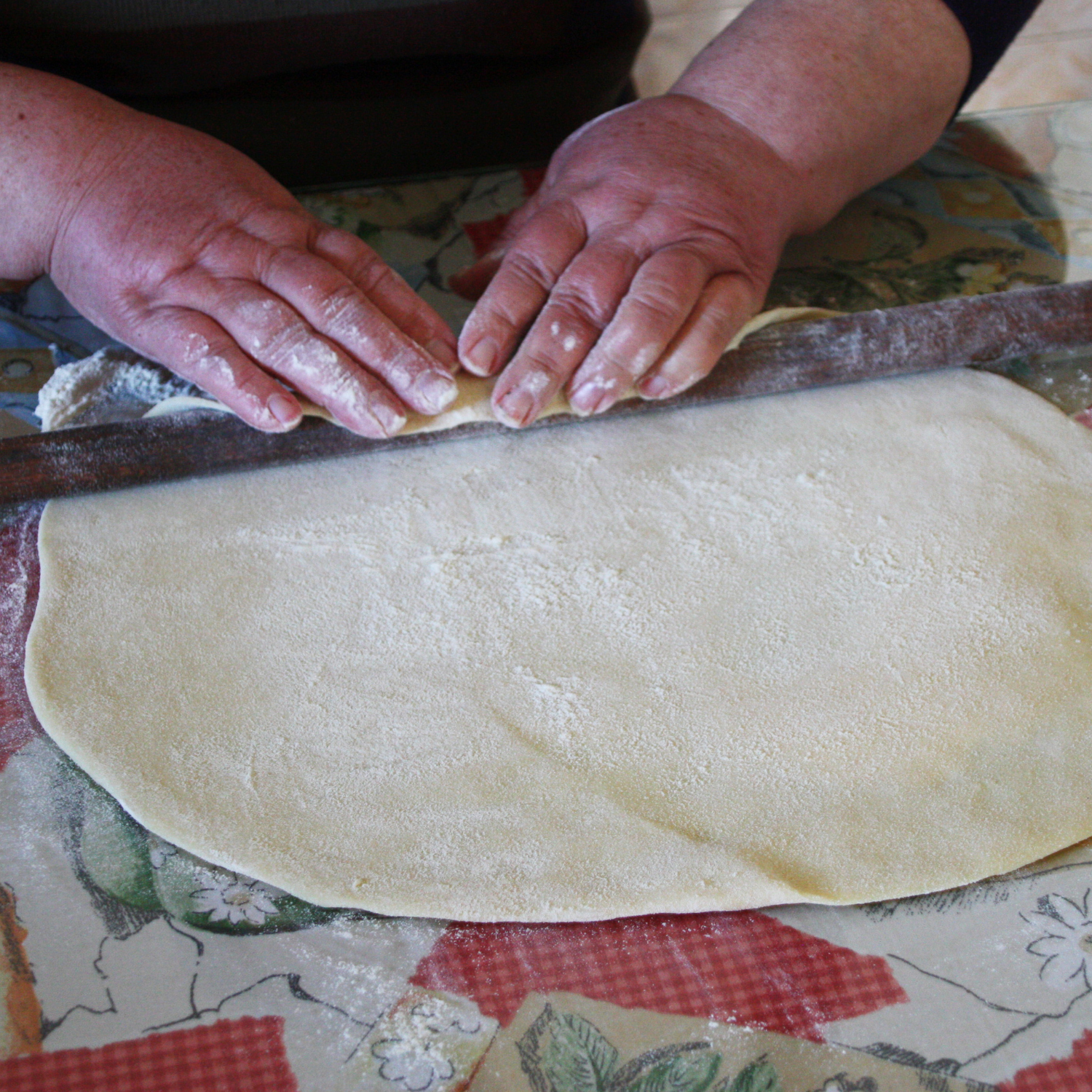 Hands of a woman rolling a dough