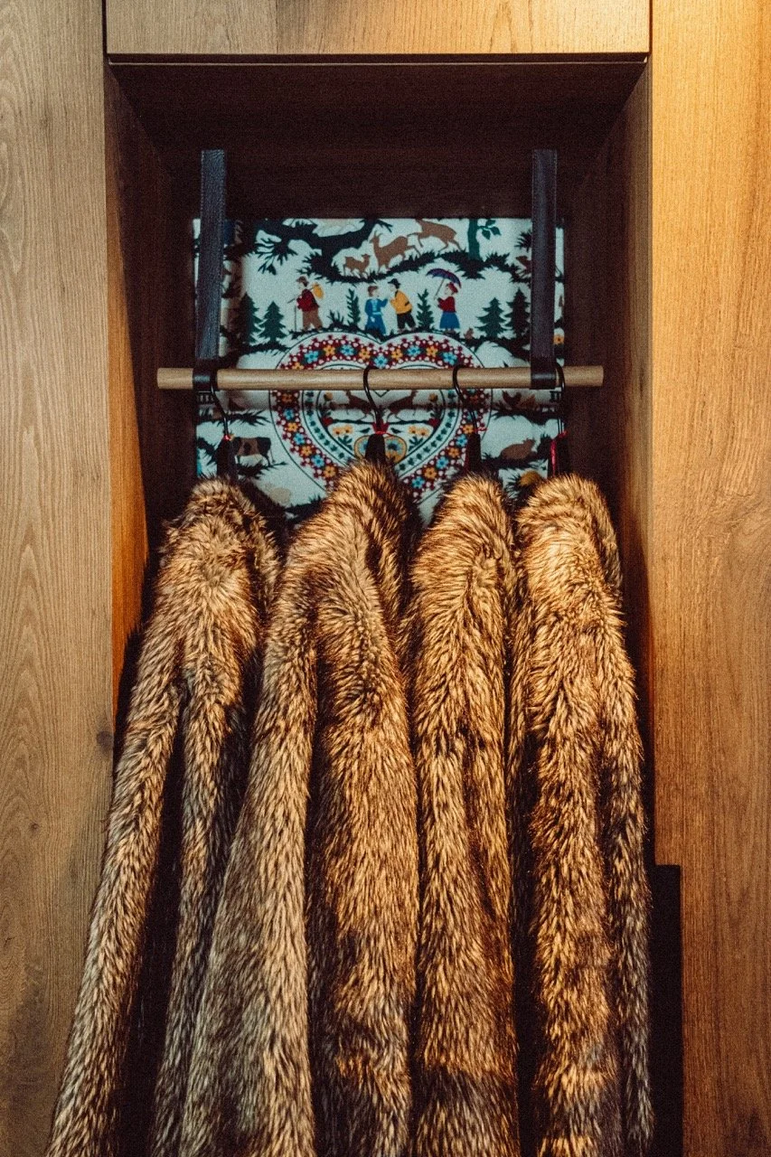 A close-up shot of furs hanging in a decorated closet