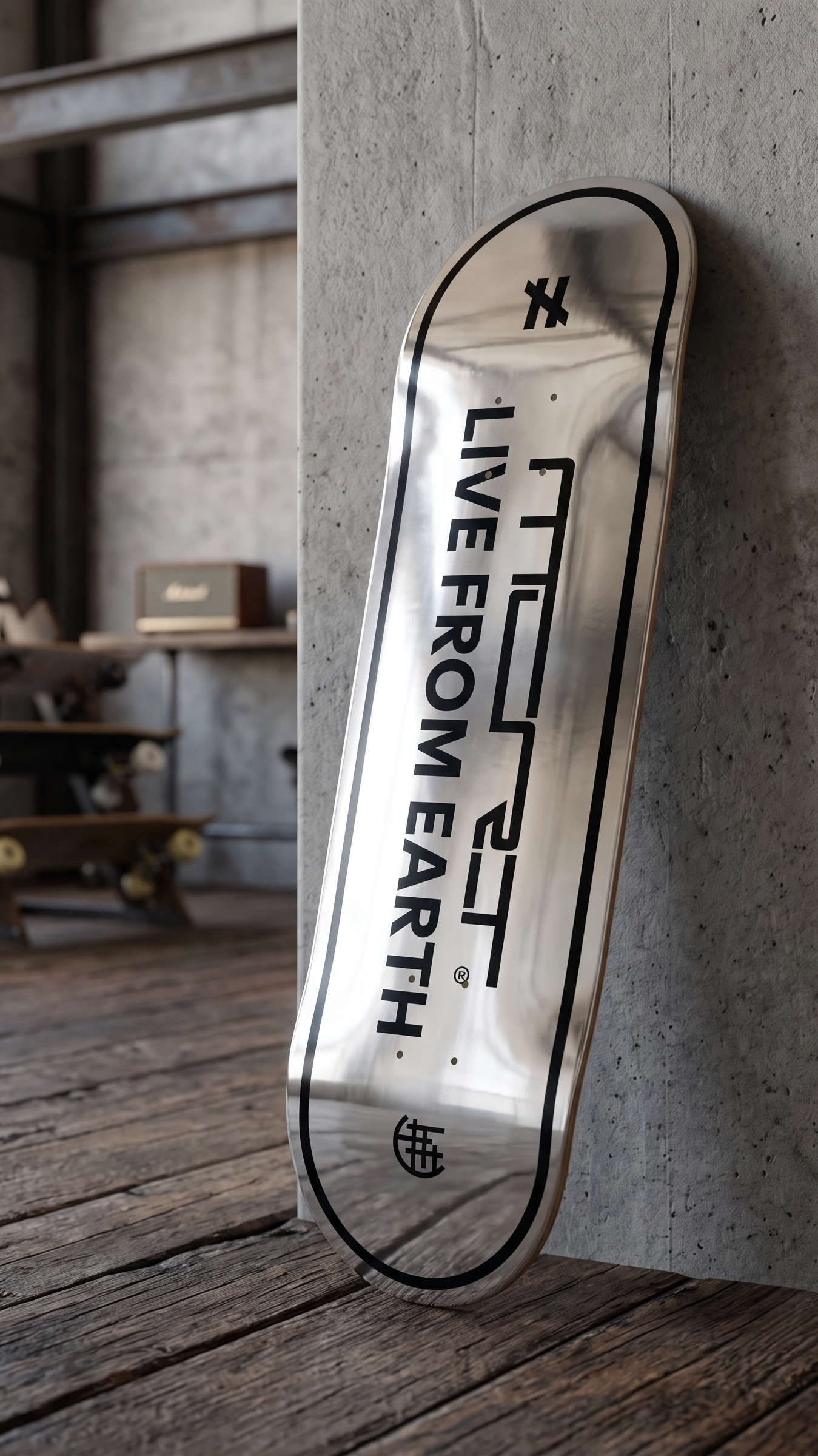 Silbernes Skateboard von MCRT mit schwarzem Text und Logo, lehnt an einer grauen Wand in einem Raum mit Holzboden, im Hintergrund sind Regale und Skateboards sichtbar.