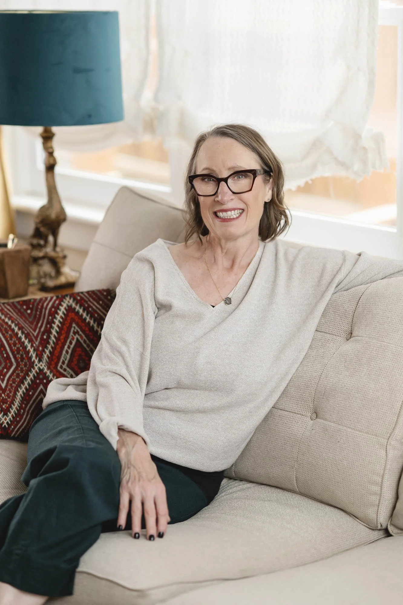 Lifestyle portrait of the Lamplit Atelier founder on her sofa