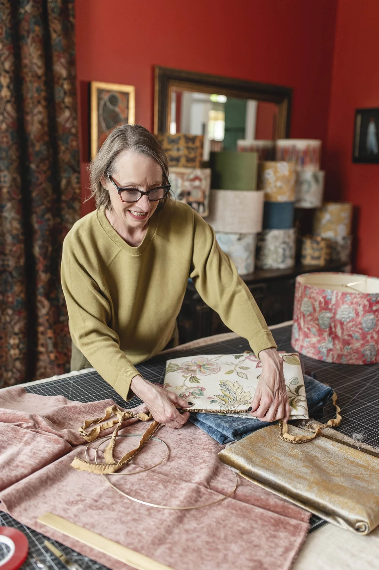 Lamplit Atelier founder selecting velvets and embroidered florals at her cutting table