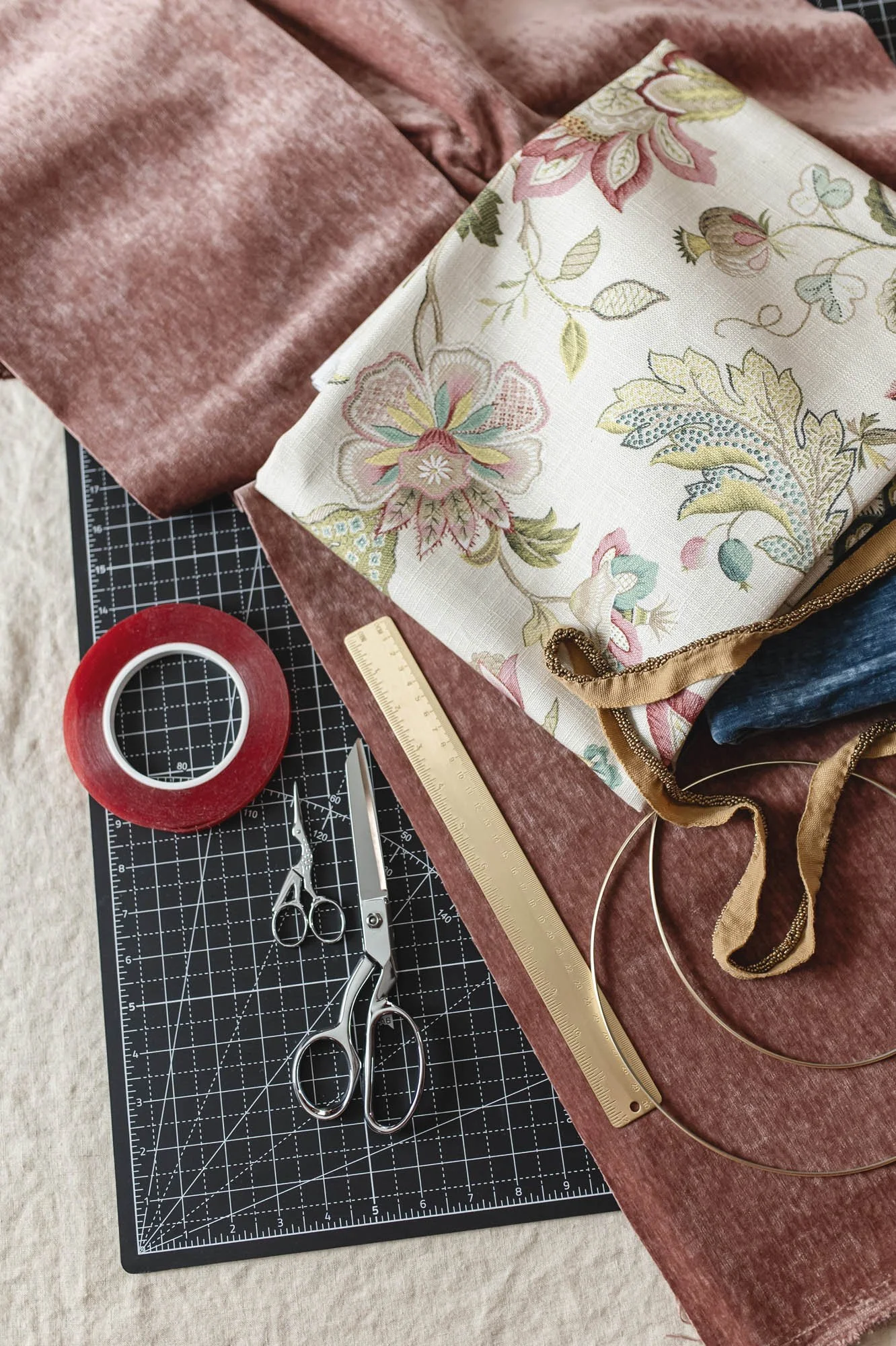Vertical flat-lay of custom Lamplit Atelier lampshade materials with embroidered florals