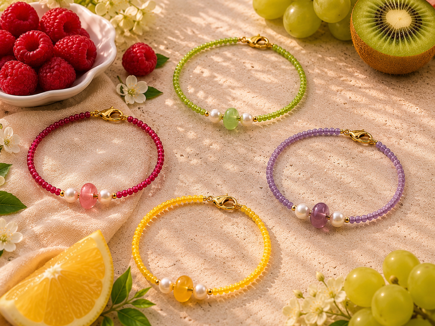 Colourful Summer Beaded Bracelets with Gemstone Charms | Petals & Pearls. Bright summer flat lay of handmade beaded bracelets in raspberry pink, lime green and sunshine yellow with gemstone centre beads, freshwater pearls and gold clasps surrounded b